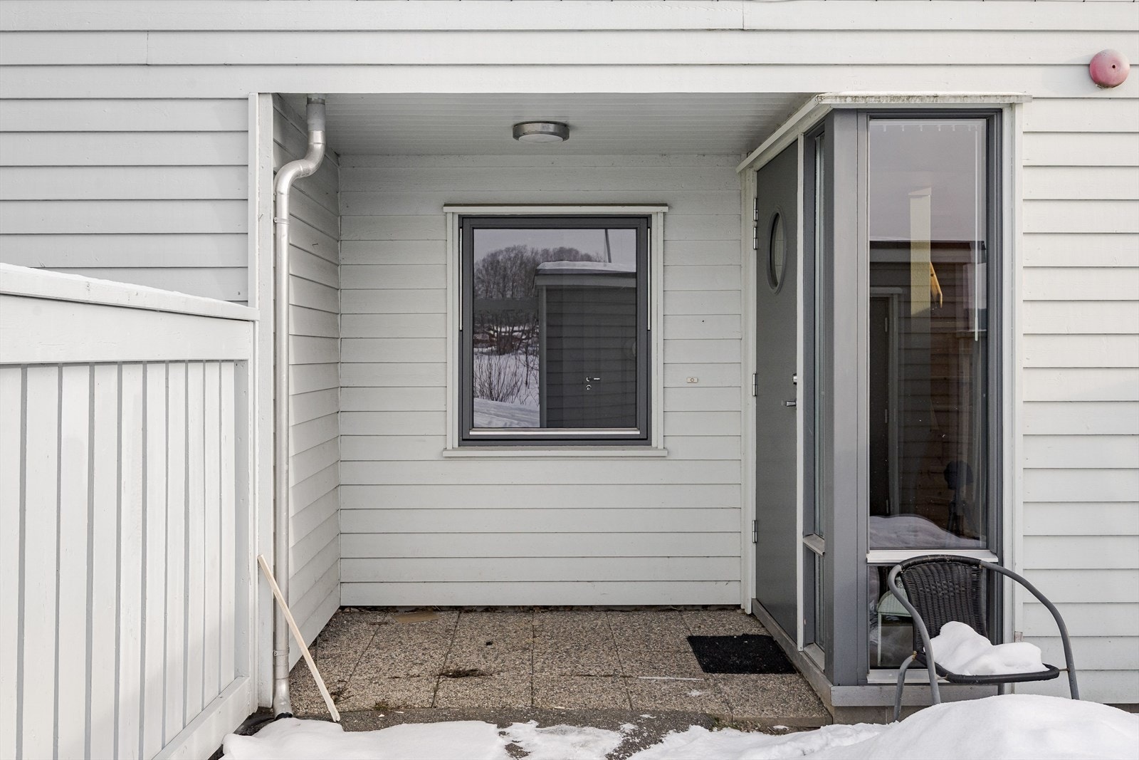 Overbygd inngangsparti med hellelagt område foran inngangsdøren. Galleribilde