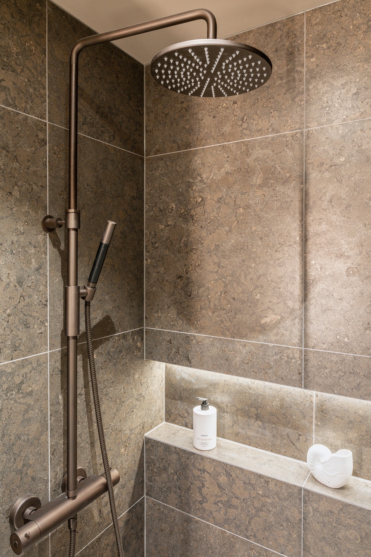 Dusjnisje med glassvegg og dør, innebygd hylle med integrert belysning og armatur fra Tapwell med både hånd- og regnfallsdusj. Galleribilde