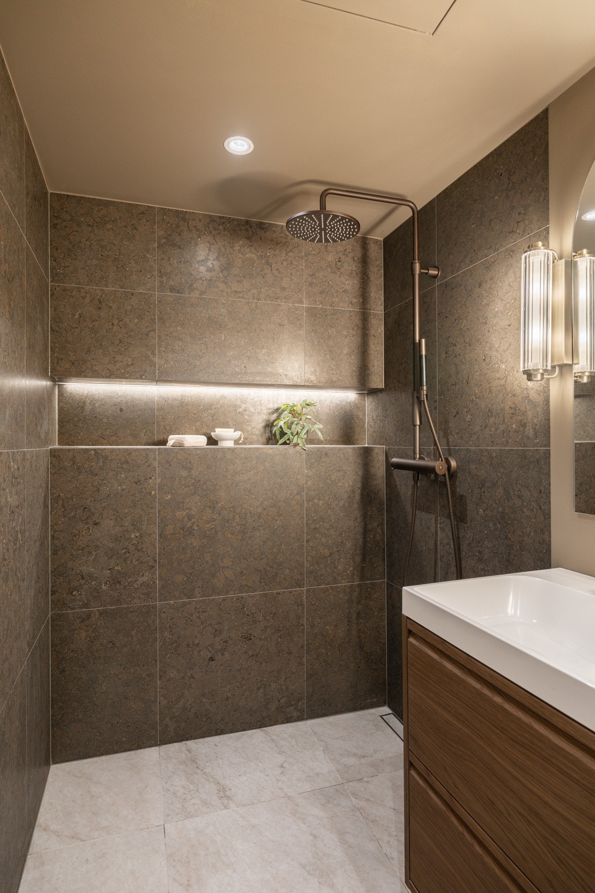 Romslig dusjnisje med integrert hylle med belysning. Det blir montert ny dusjvegg i glass før overtakelse (i bestilling). Galleribilde