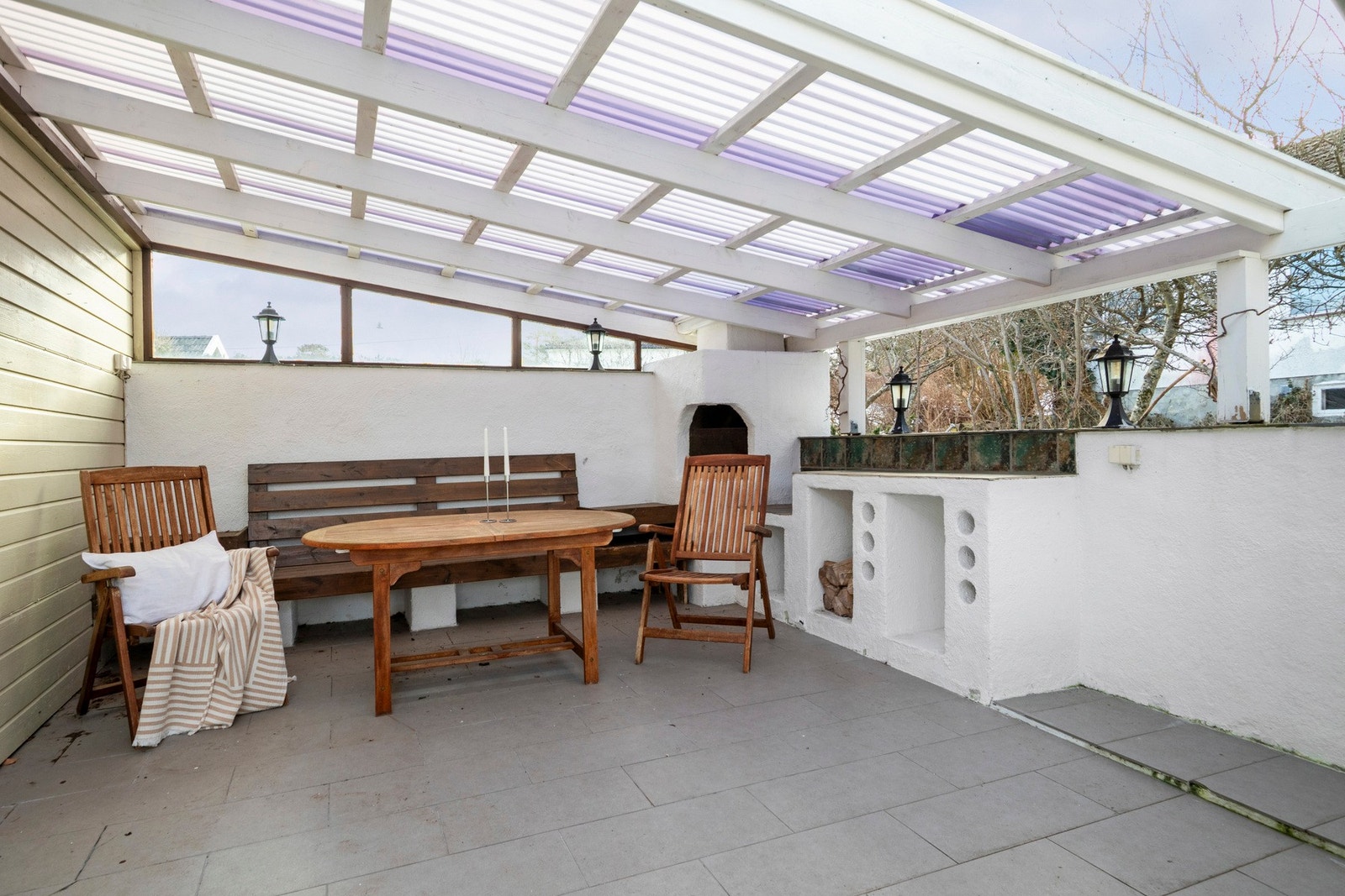 Uteplassen har integrerte hyller, plassbygd sittebenk og utepeis som forlenger sommerkveldene og gir en hyggelig atmosfære. Galleribilde