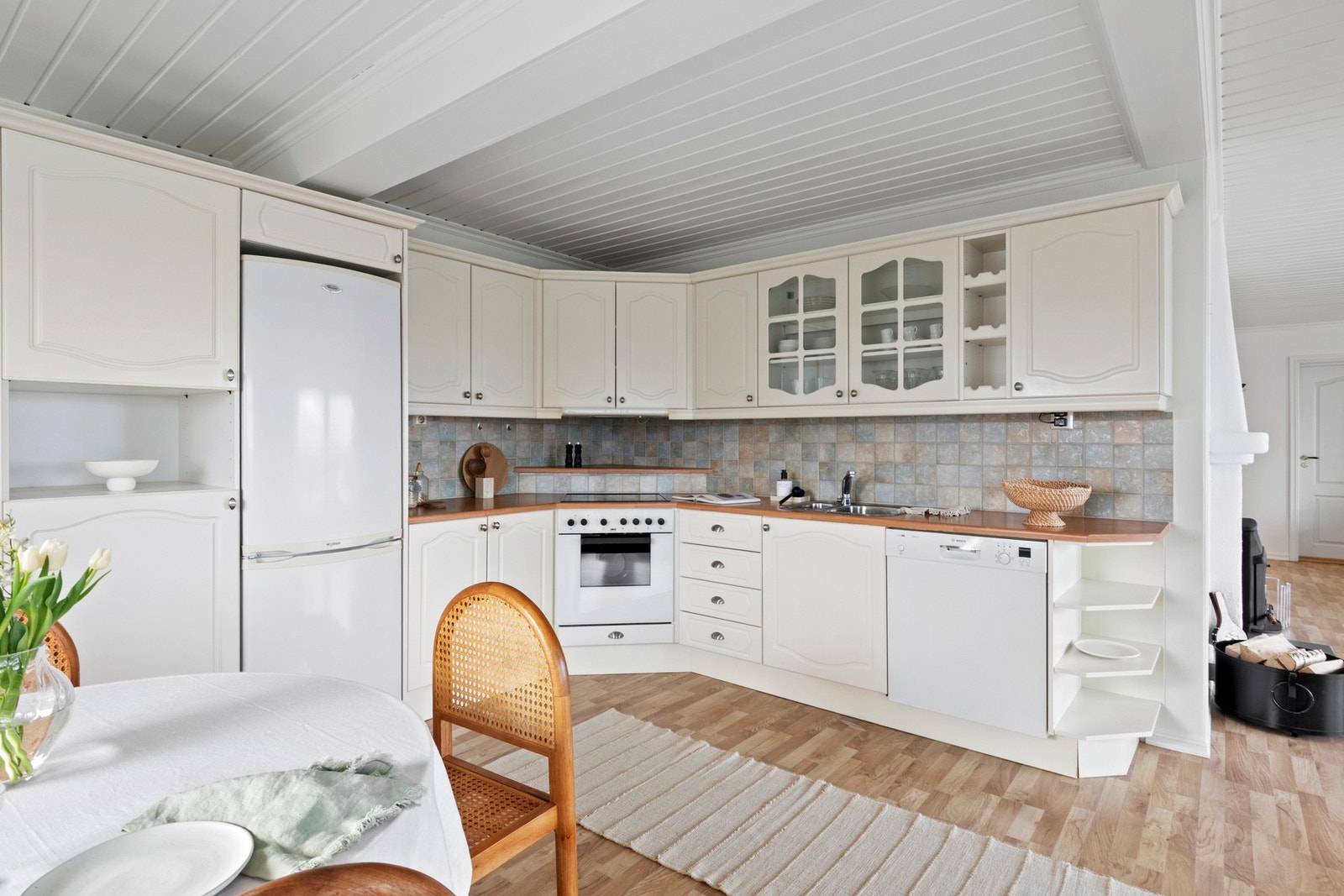 Innredningen består av lyse, profilerte fronter, vitrineskap, vinhyller, dobbel oppvaskkum og laminatbenkeplate. Galleribilde