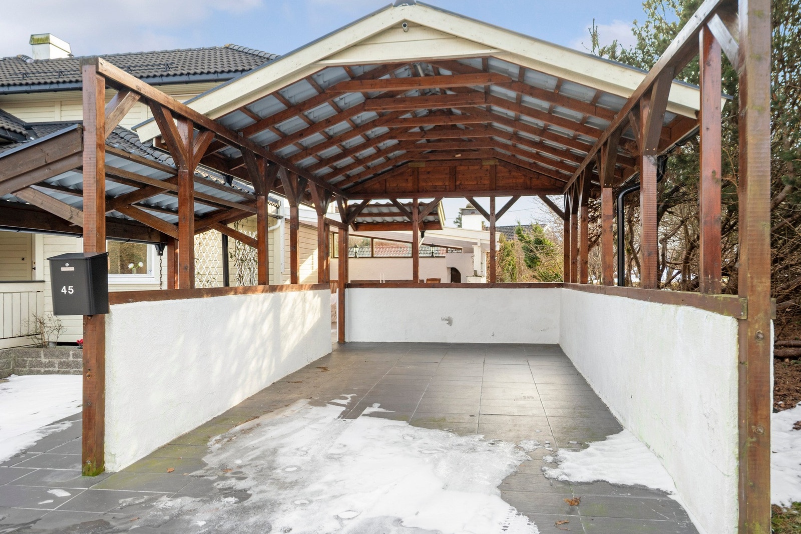 En flislagt carport med god takhøyde gir praktisk og beskyttet parkering. Galleribilde