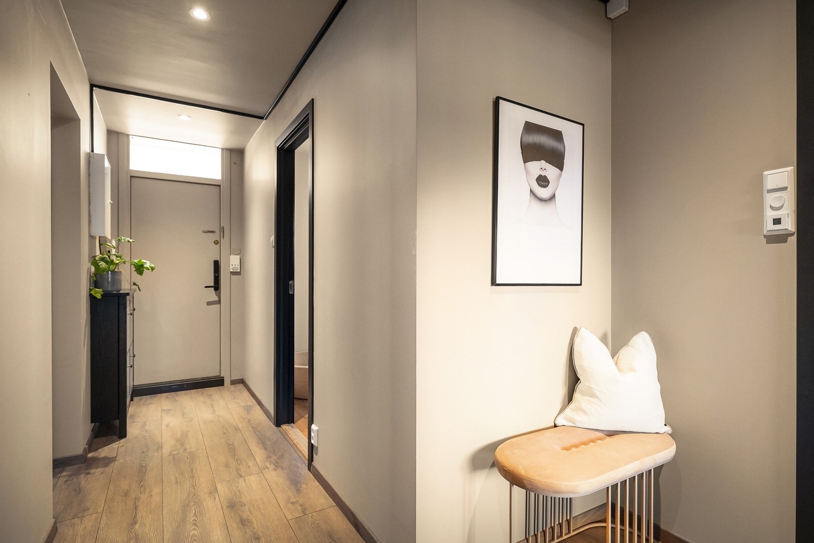 Entréen er lys og innbydende med gjennomgående parkett og delikate, nøytrale veggflater. Galleribilde