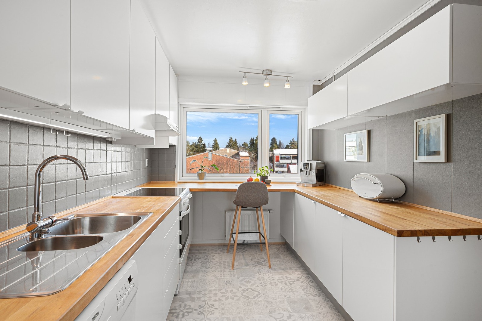 Lyst kjøkken med mye skap og benkeplass. Galleribilde