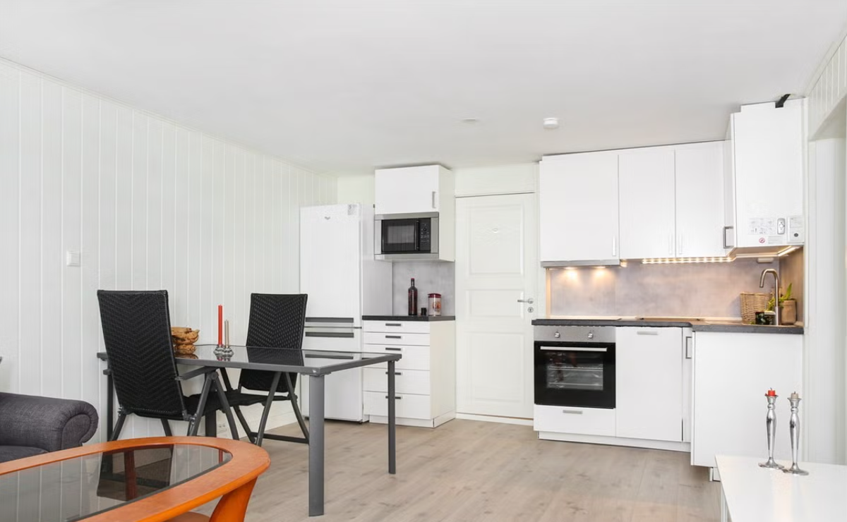 Stilrent kjøkken fra Ikea med integrert komfyr, platetopp og oppvaskmaskin Galleribilde