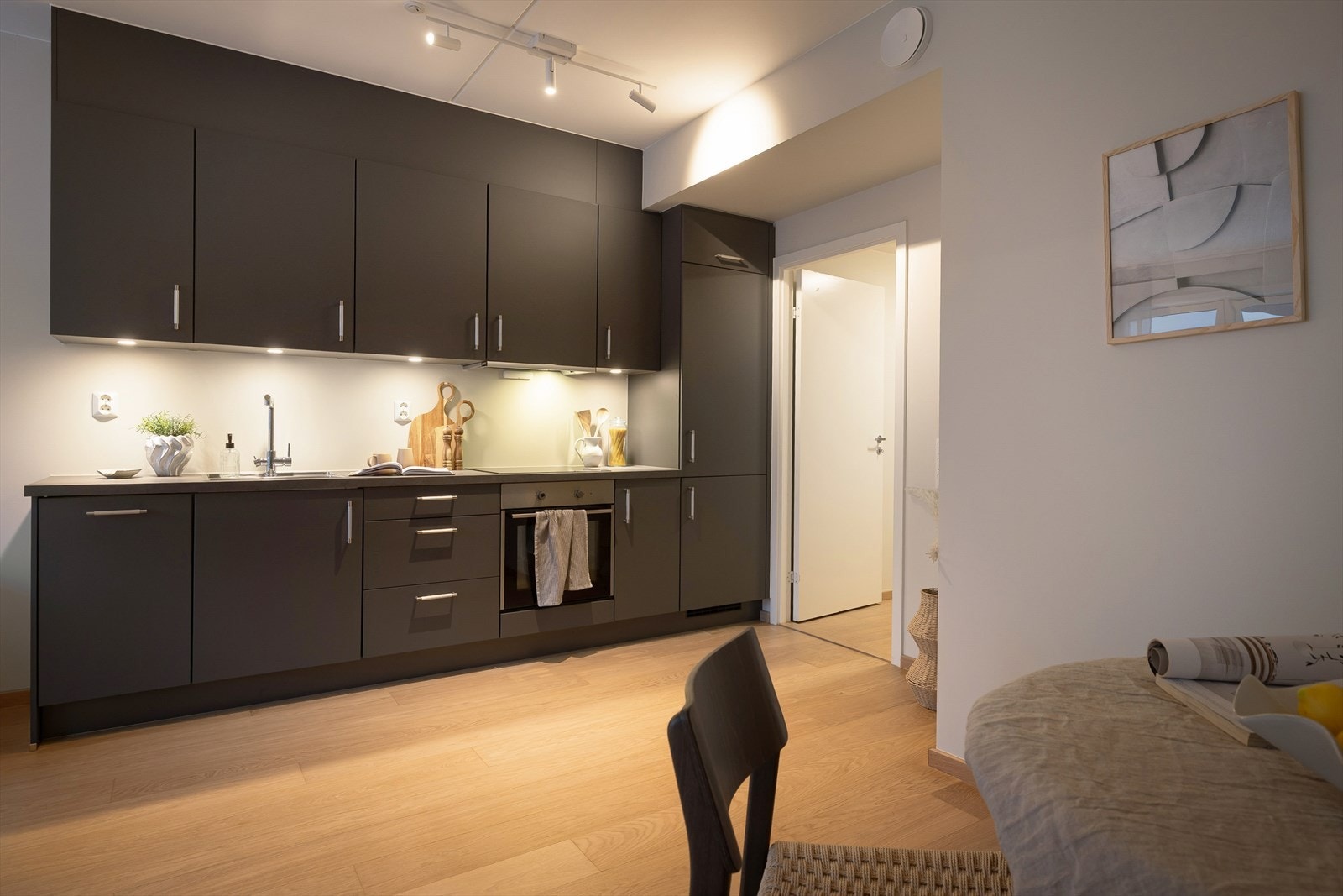 Pent kjøkken med mørke, slette fronter og ellers god med både skap- og benkeplass. Galleribilde