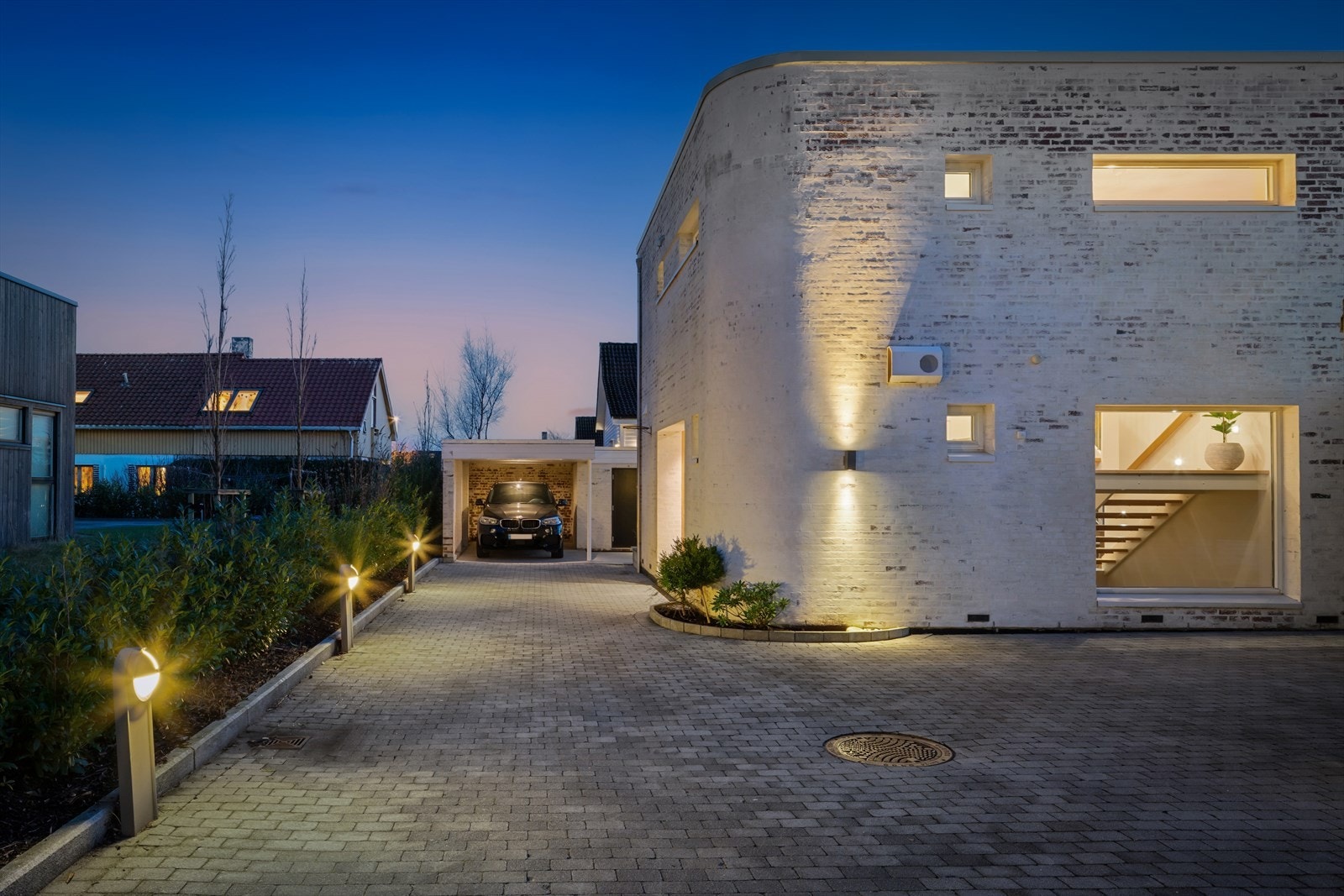 Utvendig er det hvitpusset teglstein og trekledning kombinert på en helhetlig måte, og sammen med fasadens avrundede hjørner gir dette boligen et karakteristisk og tidløst uttrykk. Galleribilde