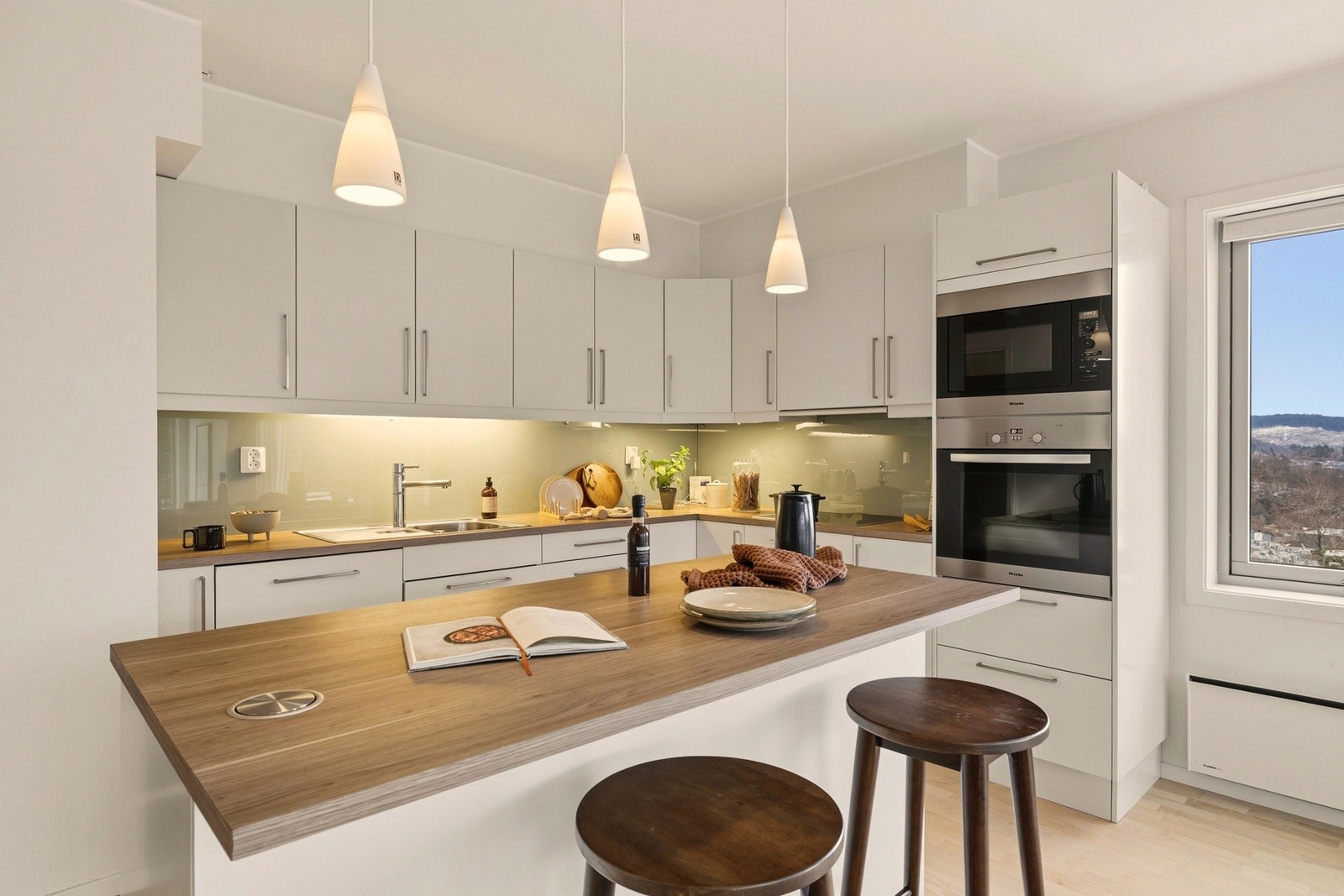 Stilrent og moderne Sigdal kjøkken med tilhørende hvitevarer. Den praktiske kjøkkenøyen gir ekstra benkeplass til kokkelering. Galleribilde