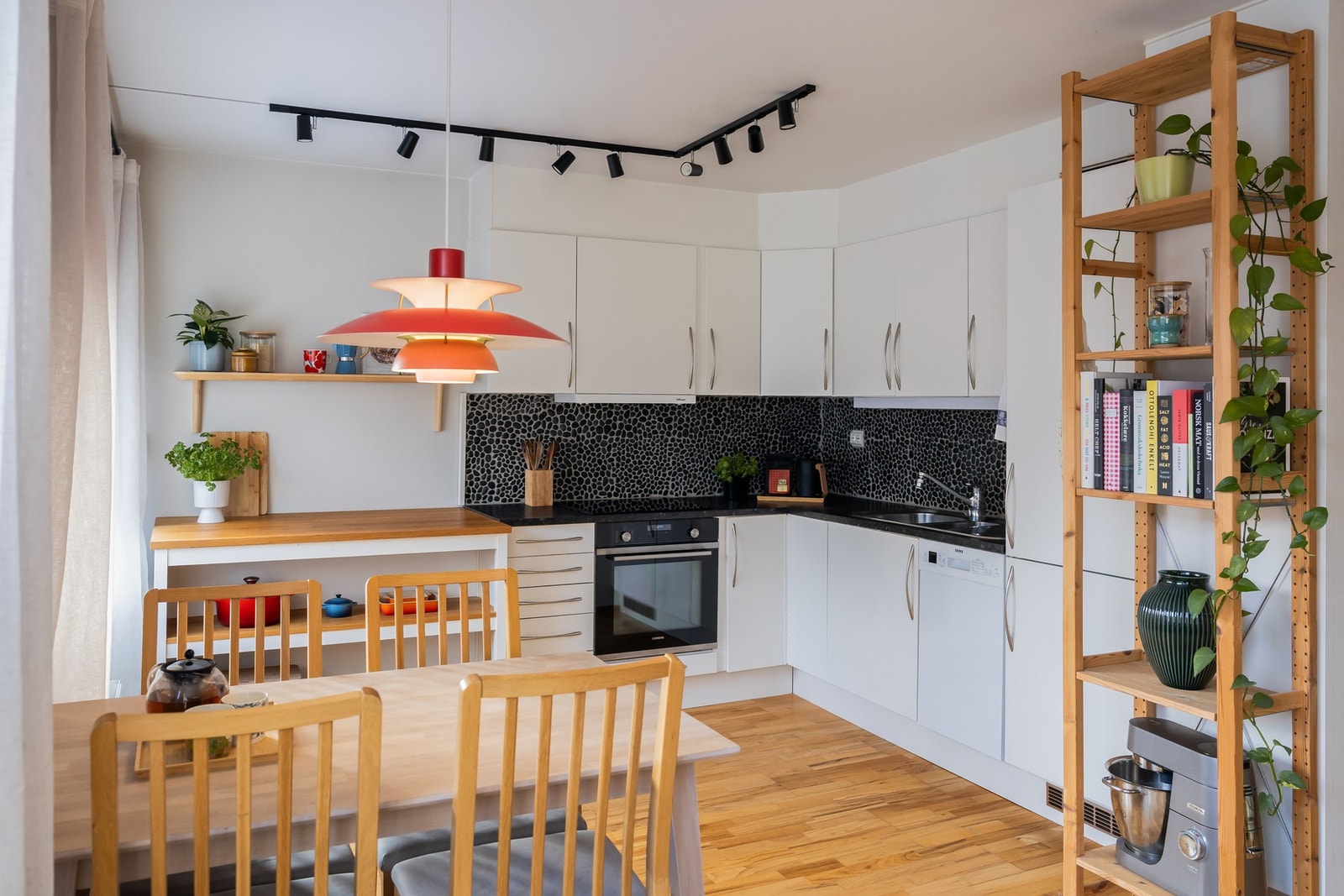 Hvit kjøkkeninnredning fra HTH. Lagt stein mellom over- og underskap. Galleribilde