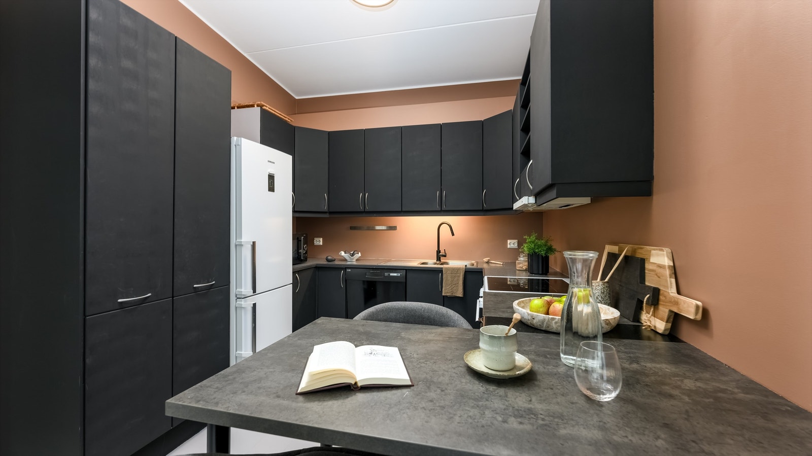 Kjøkkenet er praktisk utformet med svarte, slette fronter og rikelig med benkeplass. Galleribilde