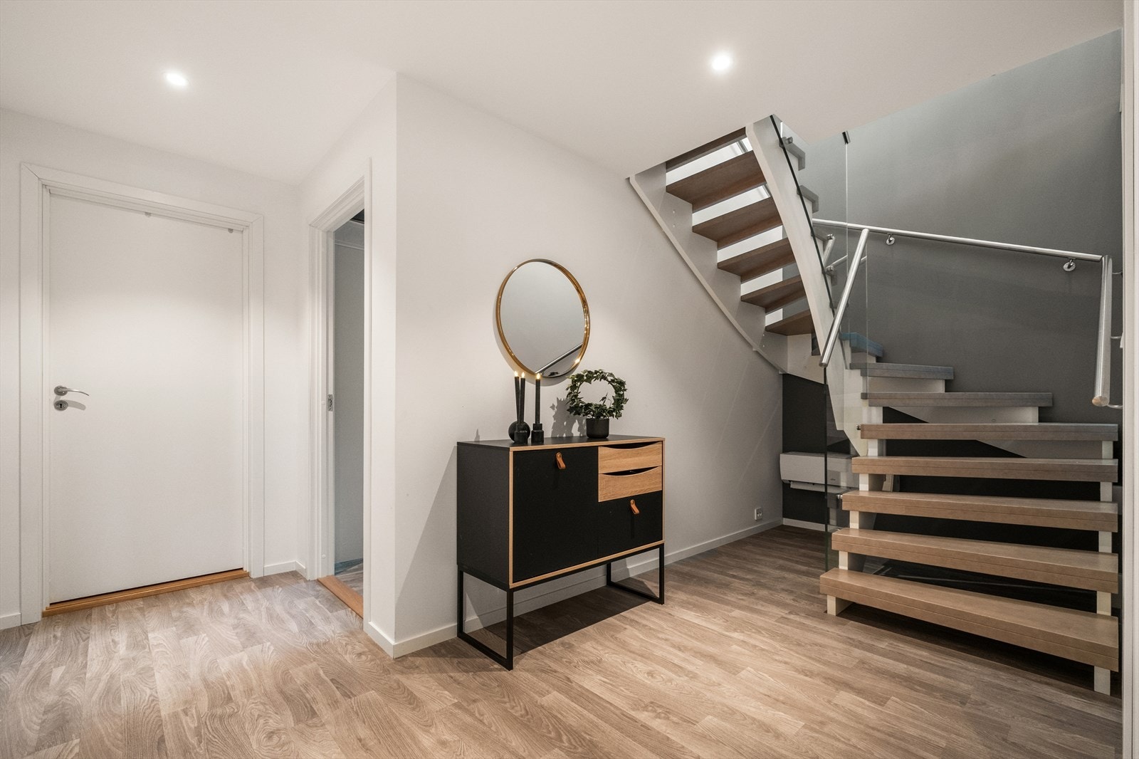 Trapp med åpne trinn og glassrekkverk er montert mellom etasjene, med varmepumpe for effektiv oppvarming av boligen. Galleribilde