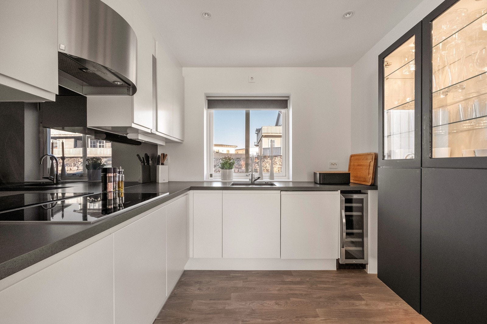 Kjøkkenet er tidløst innredet med hvite og sorte, glatte fronter og integrerte hvitevarer. Galleribilde