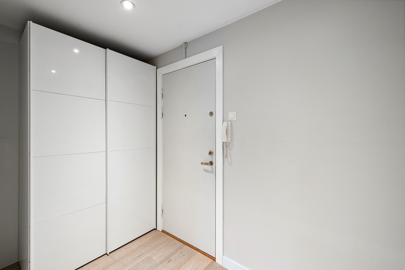 Entré med garderobeskap og felles callinganlegg montert på vegg. Galleribilde