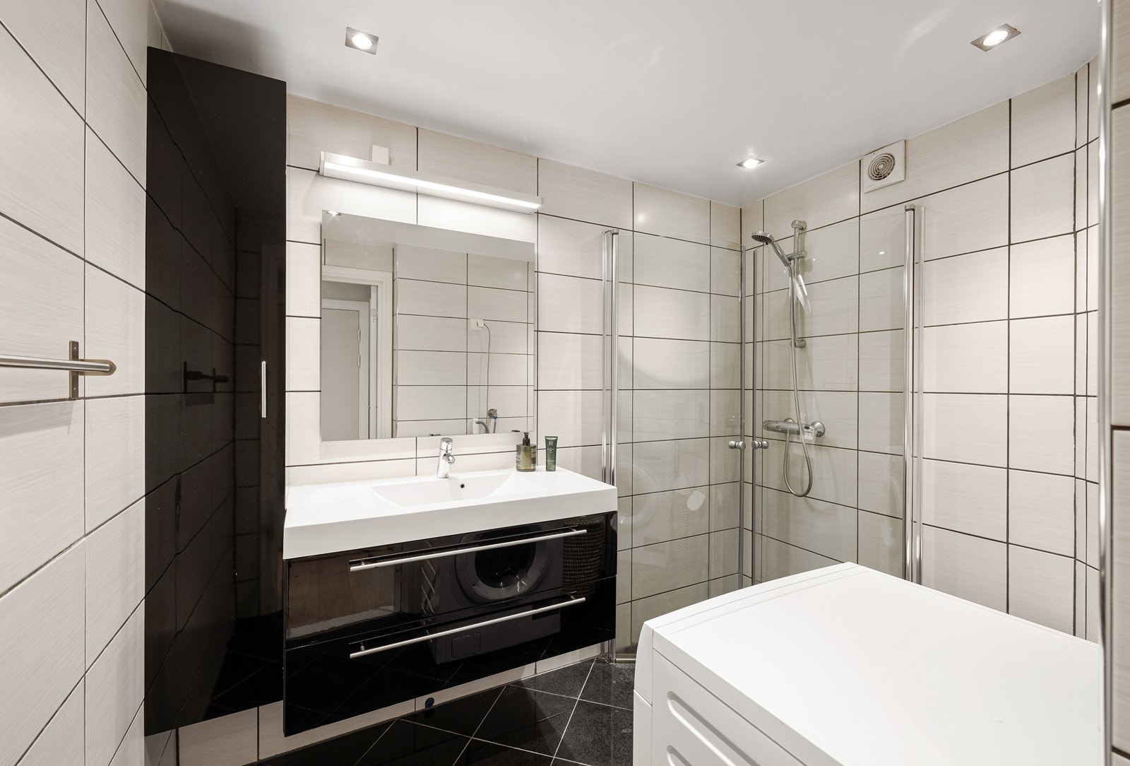 Bad fra 2009 med flislagte vegger og gulv, varmekabler og elektrisk styrt vifte. Galleribilde