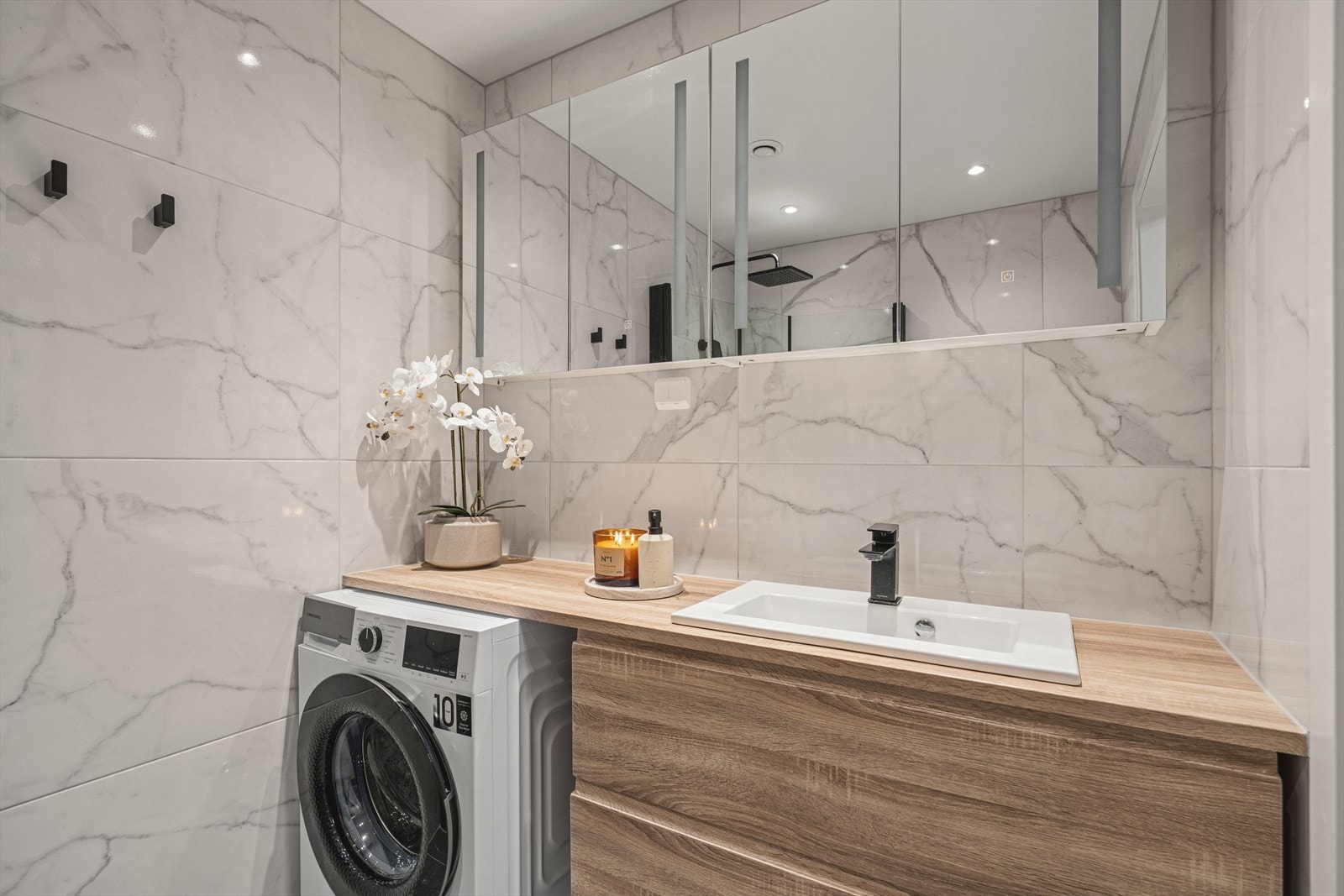 Delikate mørke fliser på gulvet med varmekabler. Lysere veggfliser sørger for et innbydende bad. Moderne løsninger og utnyttelse av badet Galleribilde