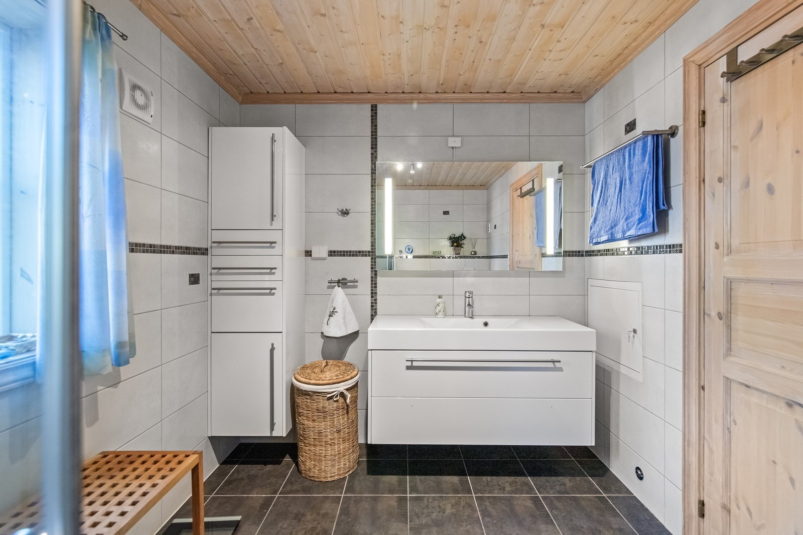 Badet er romslig og innredet med dusjhjørne, servant i innredning, bide og vegghengt toalett Galleribilde