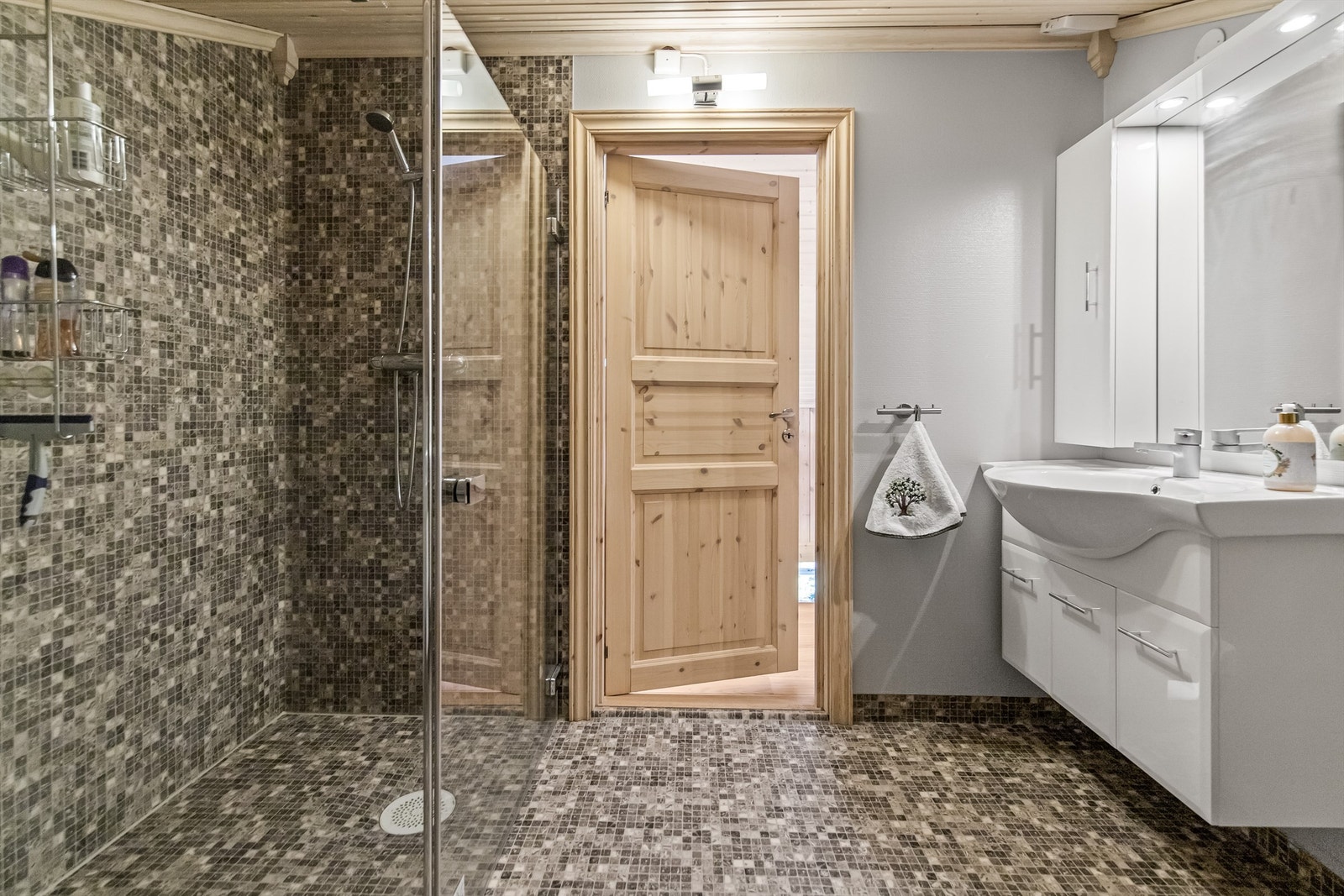 Innredet med varmekabler i gulv, dusjnisje, vegghengt toalett og servant i innredning Galleribilde