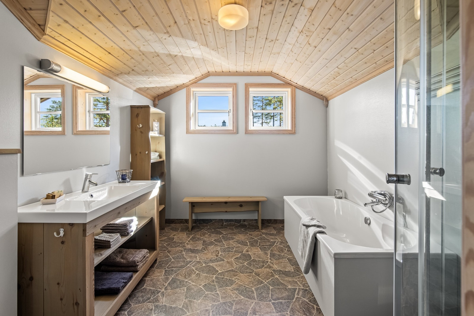 Bad i 2. etasje med badekar, dusjkabinett, servant i innredning og vegghengt toalett Galleribilde