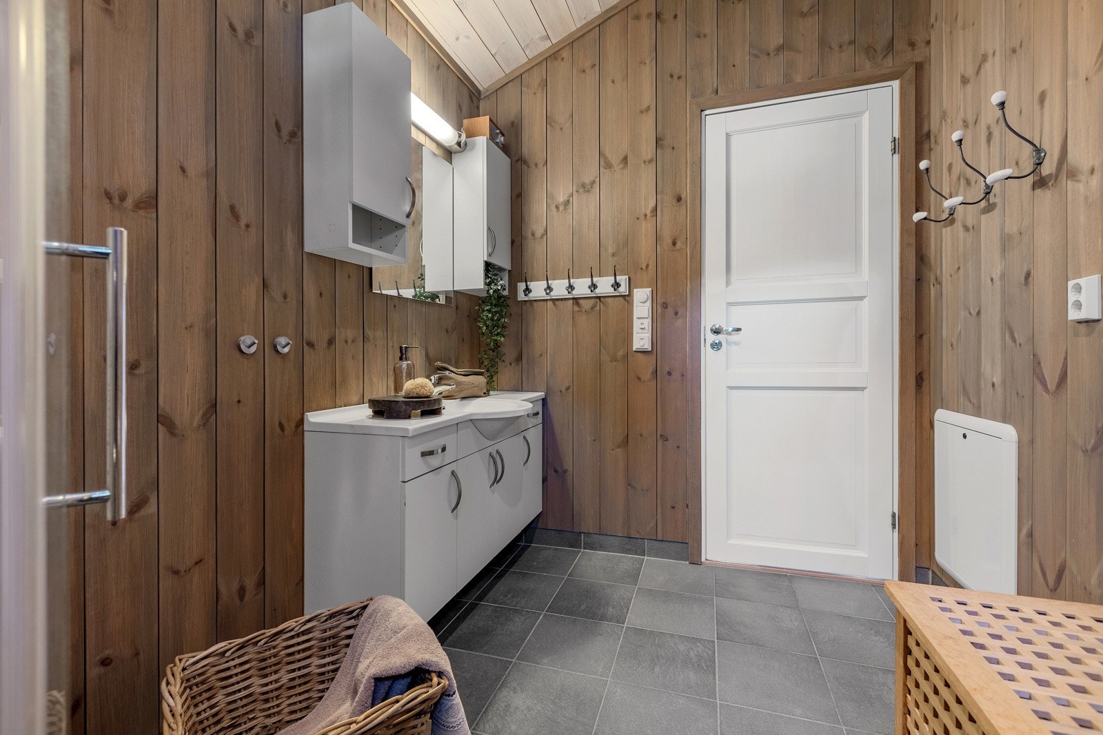 Flott bad med en kombinasjon av fliser og panel/tømmer på veggene, mens taket er kledd med panel. Galleribilde