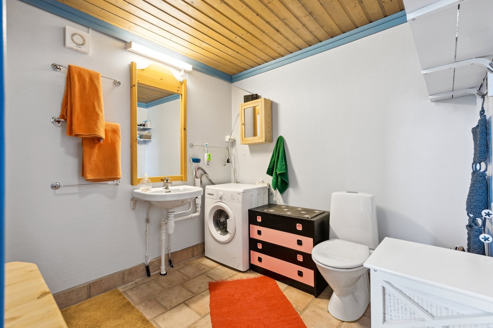 Eldre bad som er utstyrt med toalett, 2 vegghengte servanter, vaskemaskinopplegg og god plass til oppbevaring. Galleribilde