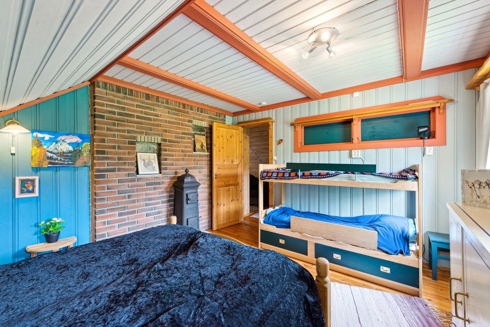 Hovedsoverom med synlig murvegg, vedovn og smarte oppbevaringsløsninger. Galleribilde