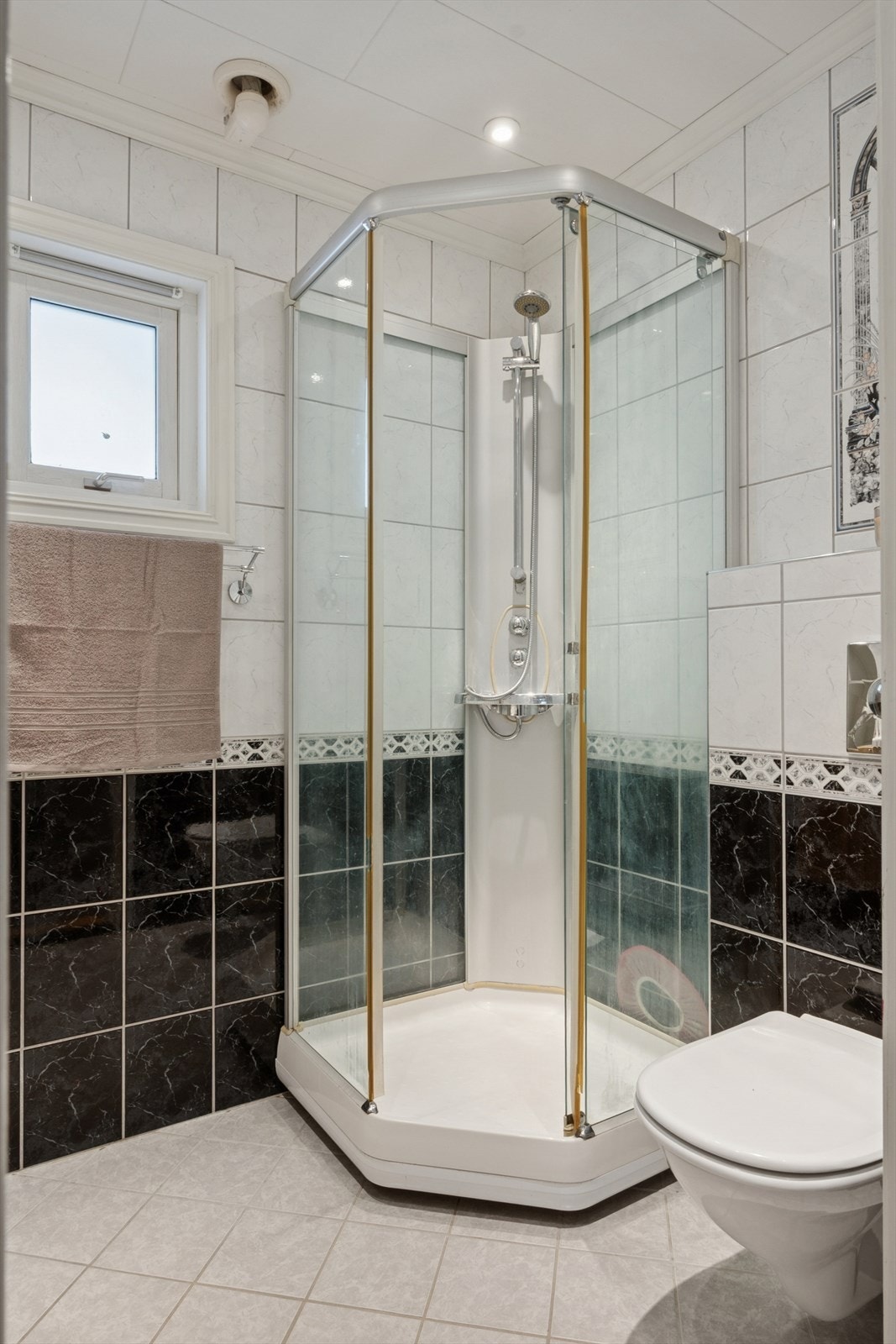 Badet er innredet med heldekkende servant med underskap, veggmontert toalett og dusjkabinett. Galleribilde