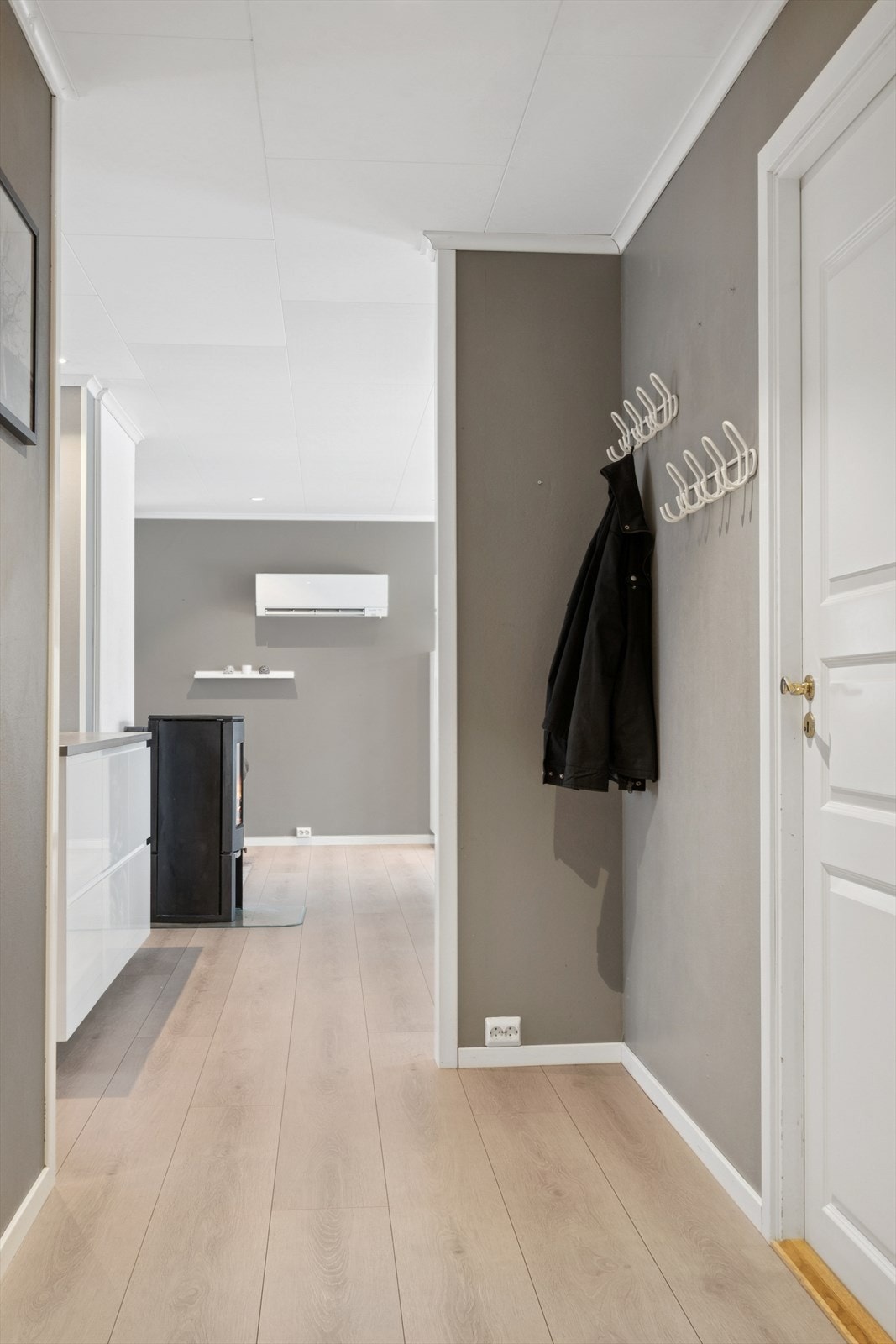 Pent laminatgulv og lyse, malte vegger er gjennomgående i hovedetasjen. Galleribilde