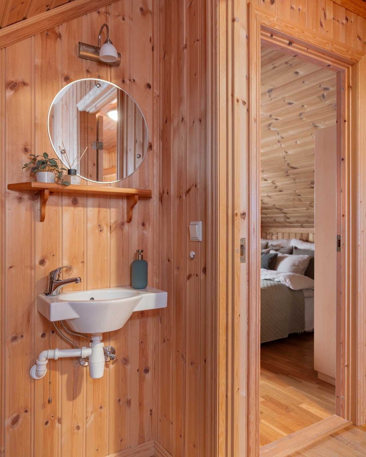 Videre har rommet enkel servant og speil med hylle i overkant. Galleribilde