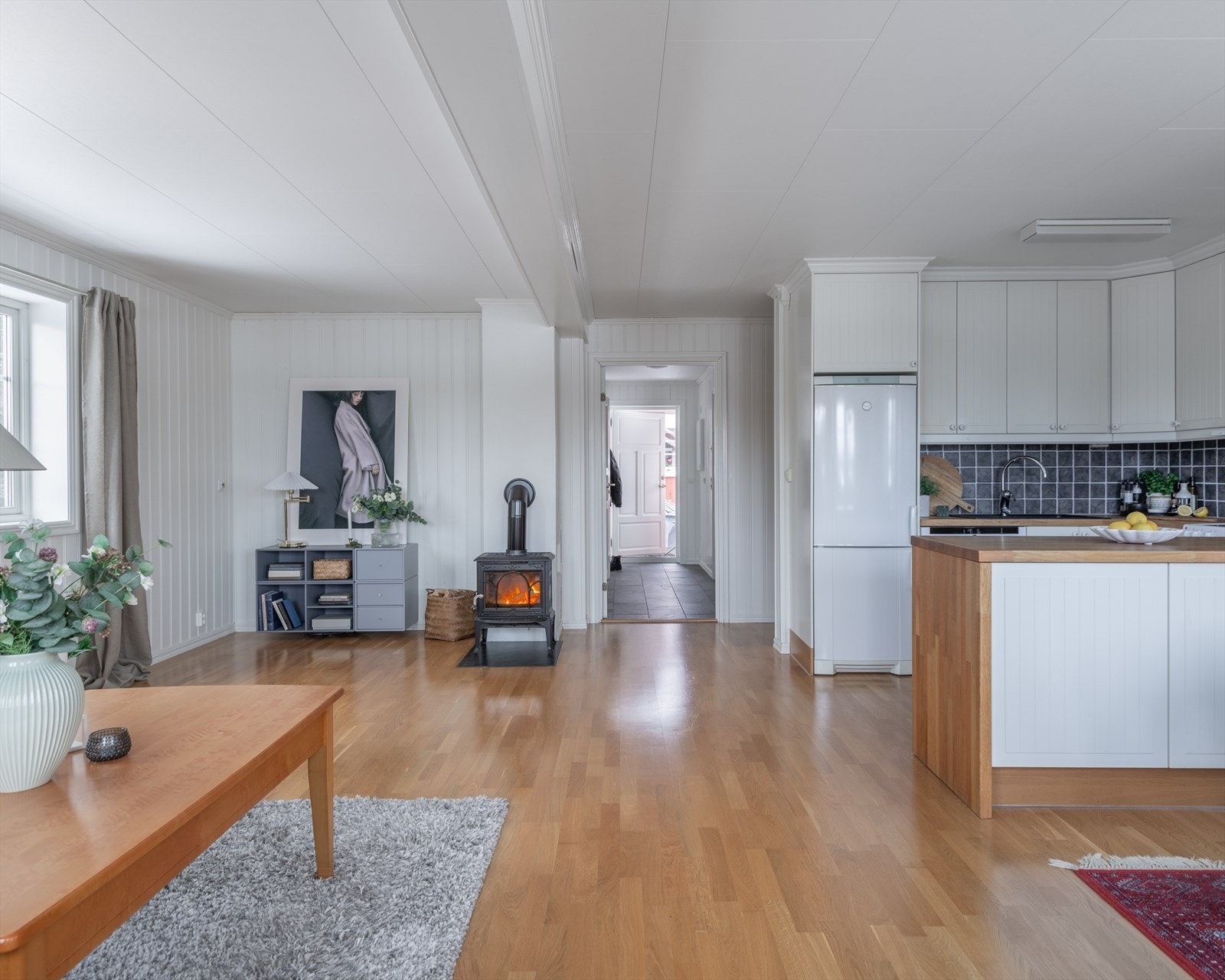 Et innbydende allrom med lysmalte vegger og trestavs eikeparkett på gulvet. Galleribilde