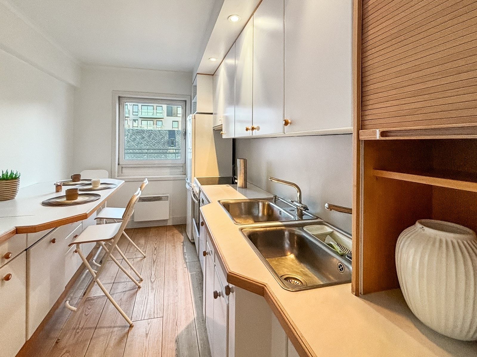 Separat kjøkken med innredning av laminerte skrog, glatte fronter og laminert benkeplate Galleribilde