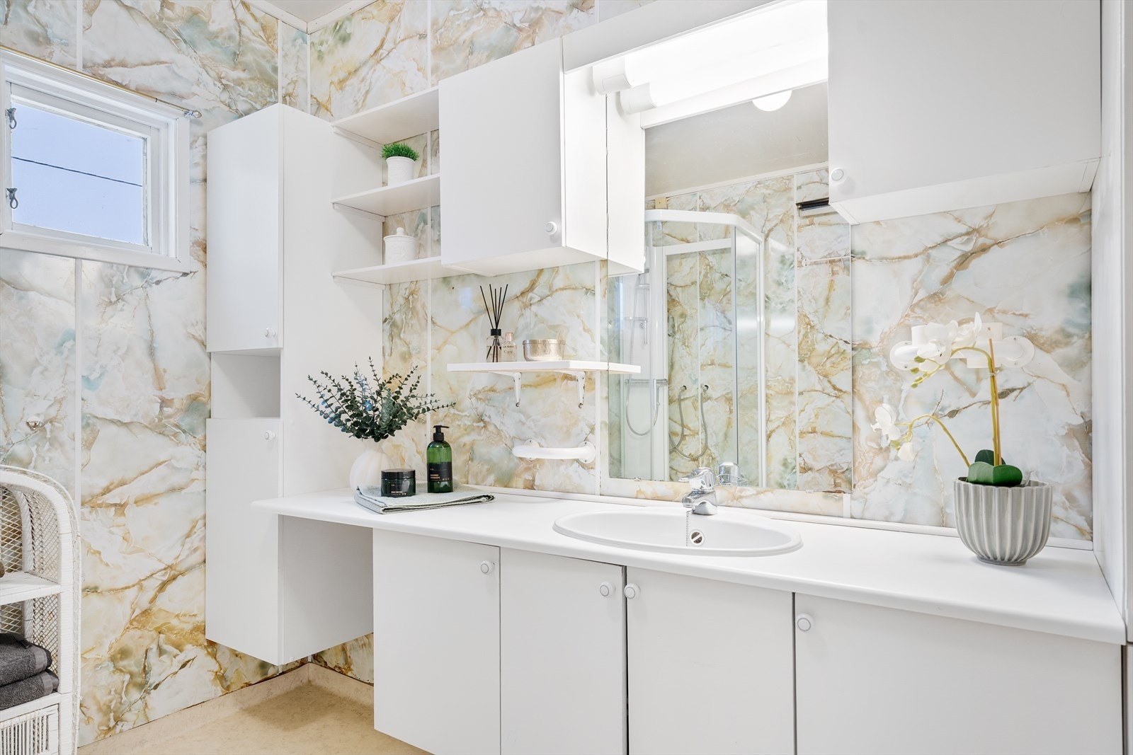 Stort eldre bad med baderomsinnredning, dusjkabinett og toalett. Galleribilde