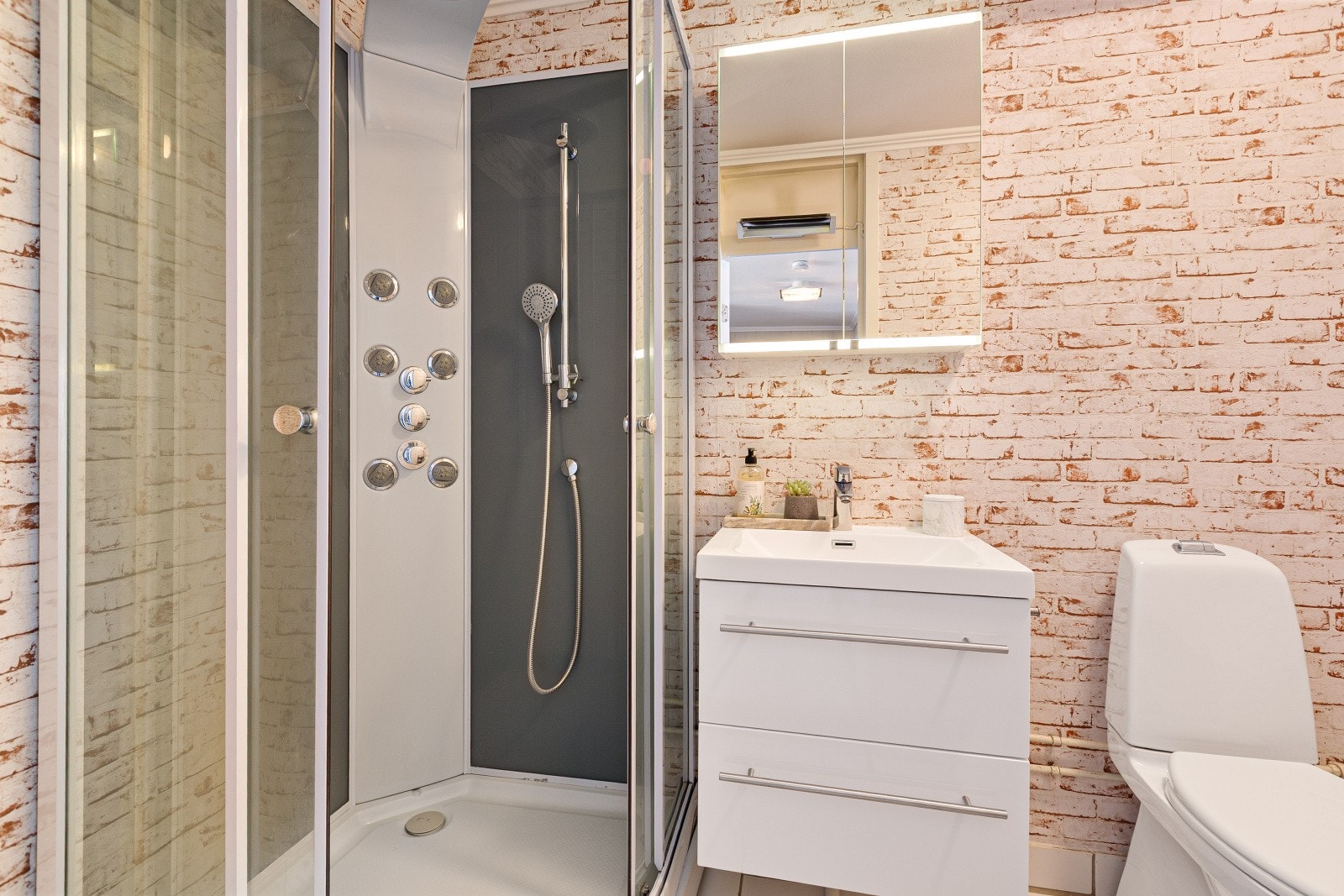 Leiligheten har et pent baderom som har flislagt gulv og våtromstapet/belegg på veggene. Galleribilde