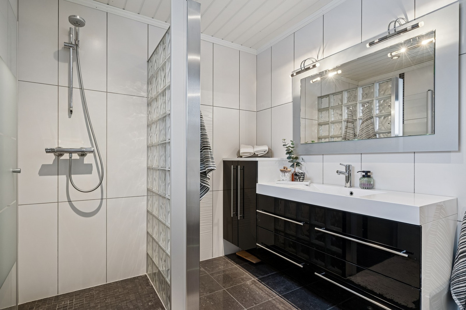 Baderommet er utstyrt med dusjnisje, stor innredning og downlights i himling. Galleribilde