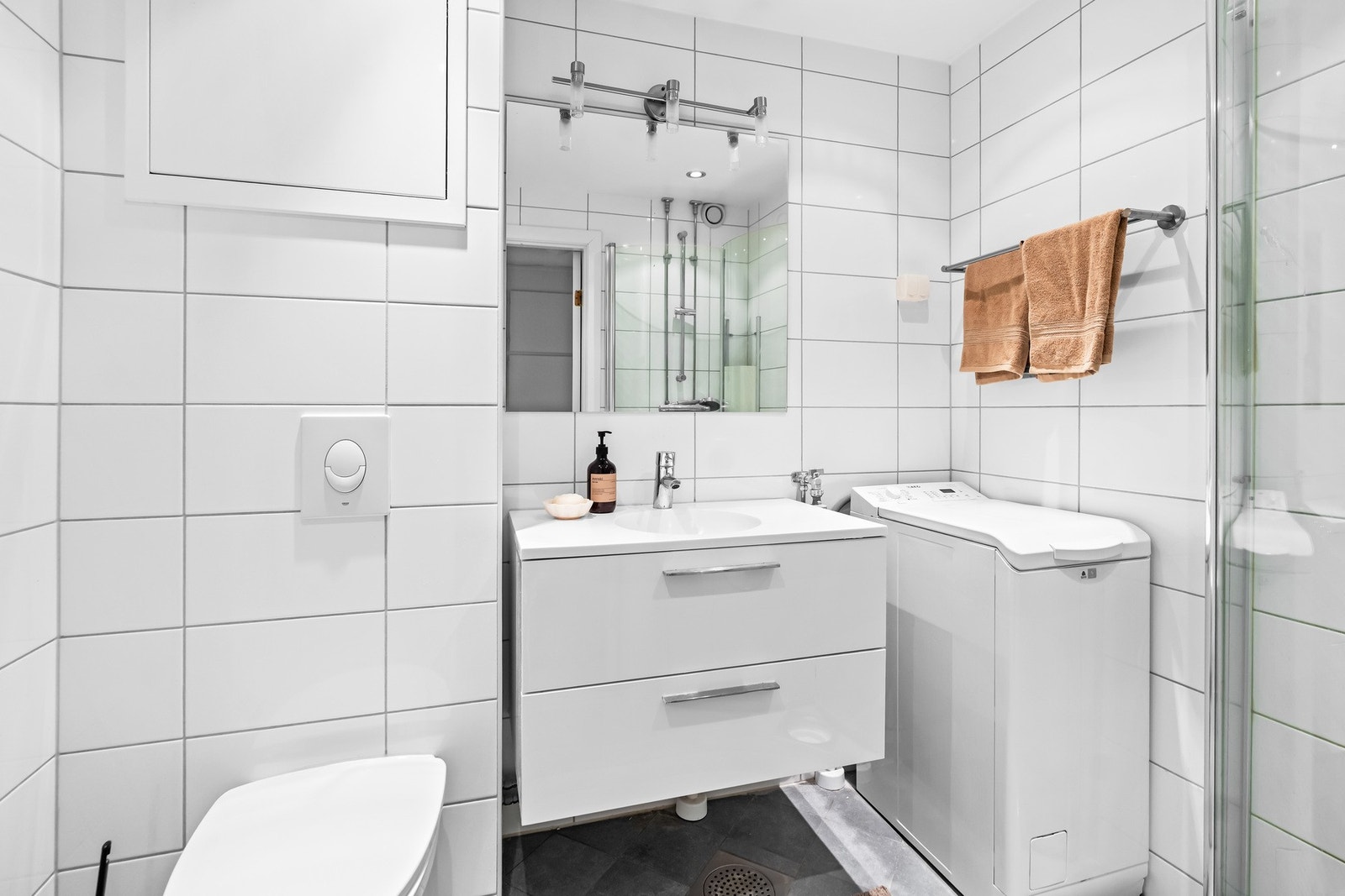 Badet har flislagte overflater med varme på gulv. Videre er det også opplegg for oppvaskmaskin og tørketrommel. Galleribilde