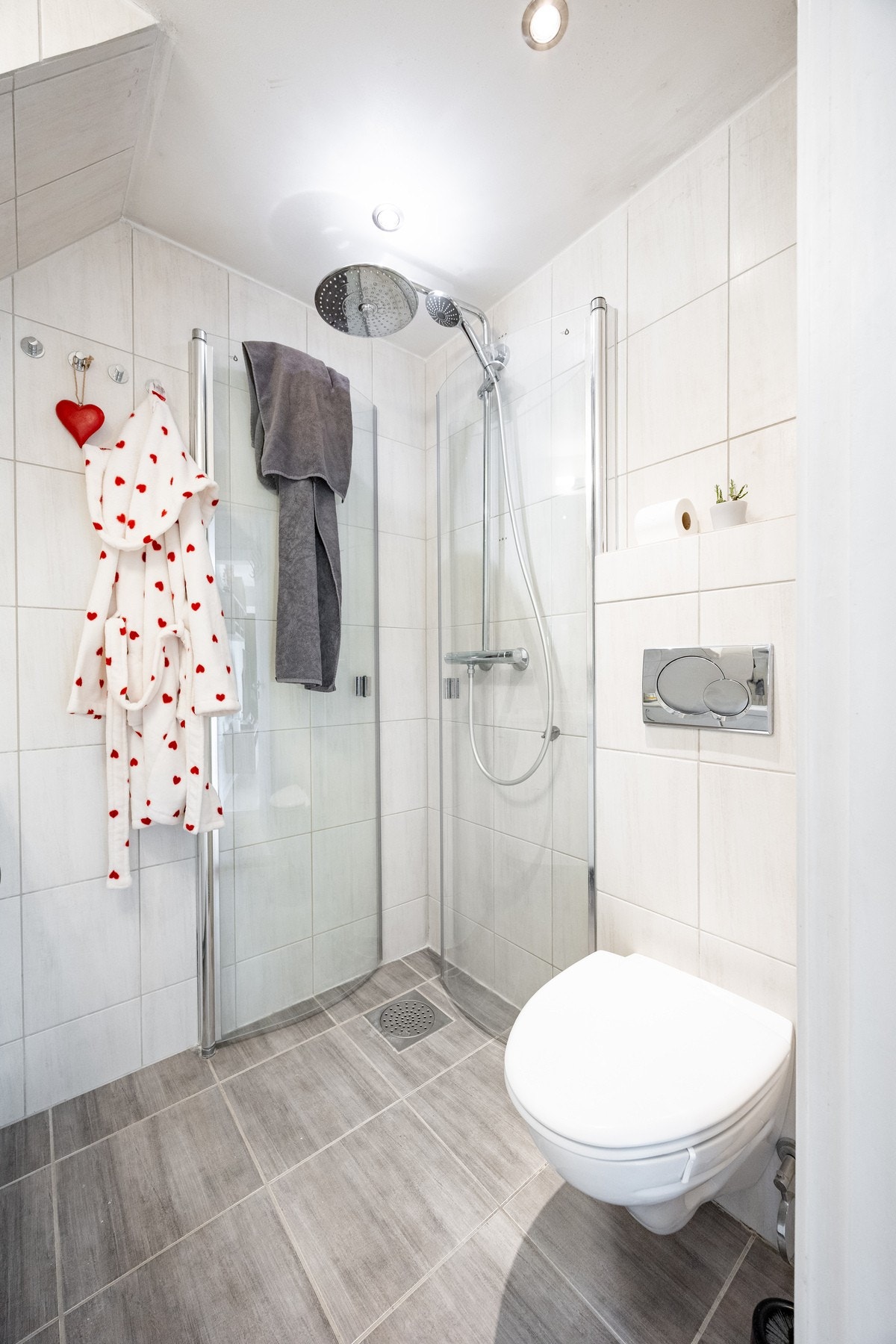 Innredningen består av servantinnredning, speil innmurt i vegg over servant, vegghengt toalett og dusjhjørne med svingbare glassdører. Galleribilde