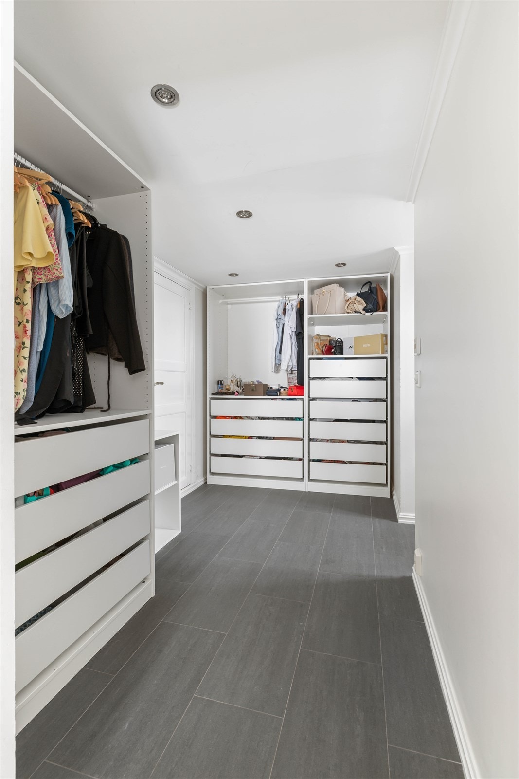 I kjelleretasjen er det innredet et walk-in closet. Rommet har downlightsbelysning og fliser på gulv. Her er det godt med skapplass for klær, sko og vesker Galleribilde