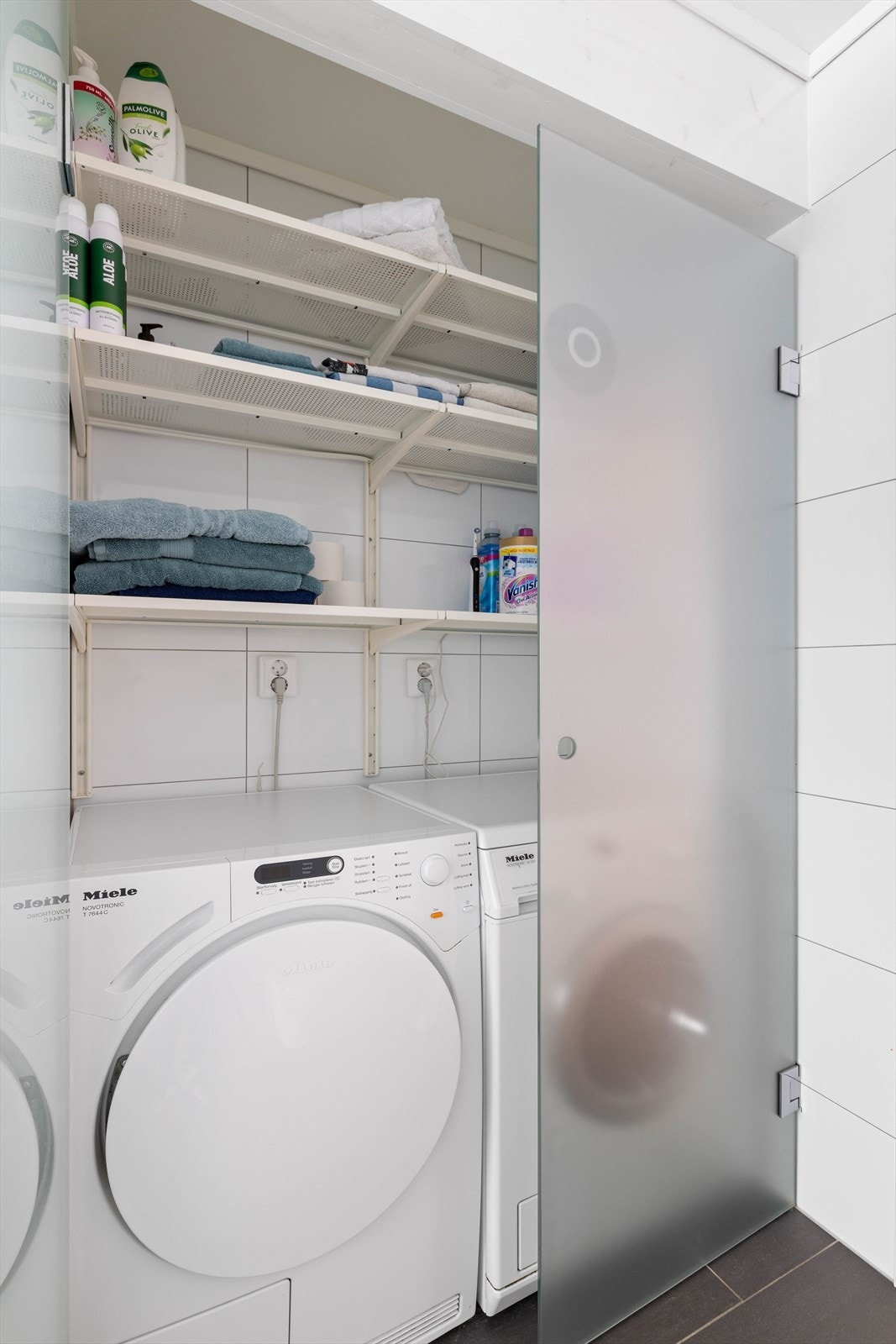Egen nisje for vaskemaskin og tørketrommel. Frostede glassdører gir mindre innsyn til klesvasken, vaskemidler og ekstra handklær Galleribilde