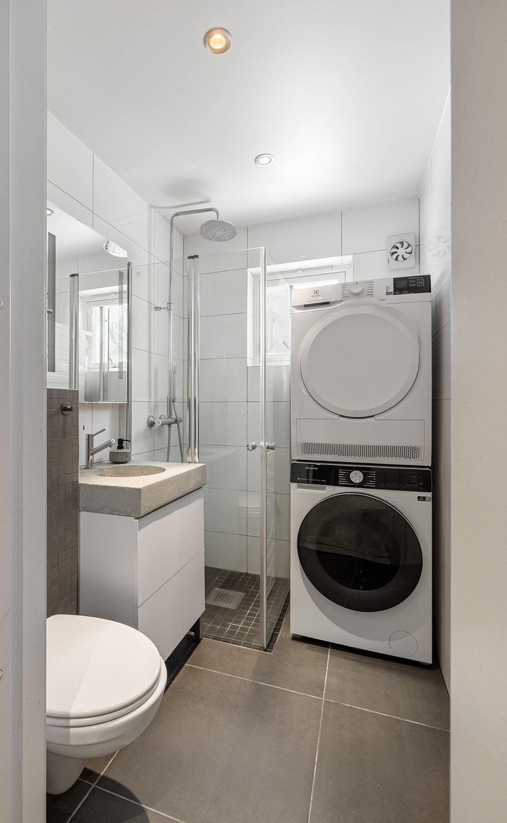 Delikat og flislagt baderom fra 2012 med varmekabler i gulv, downlights i himling, opplegg for vaskemaskin og el-styrt avtrekksvifte. Galleribilde