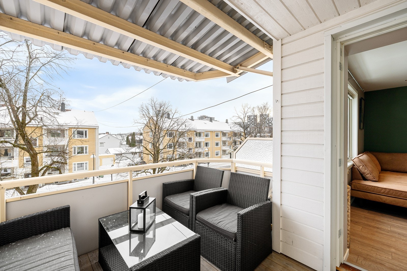 Balkongen er innredet med terrassebord. malte panelvegger og rekkverk. Downlightsene i taket lyser opp balkongen på kveldstid. Galleribilde