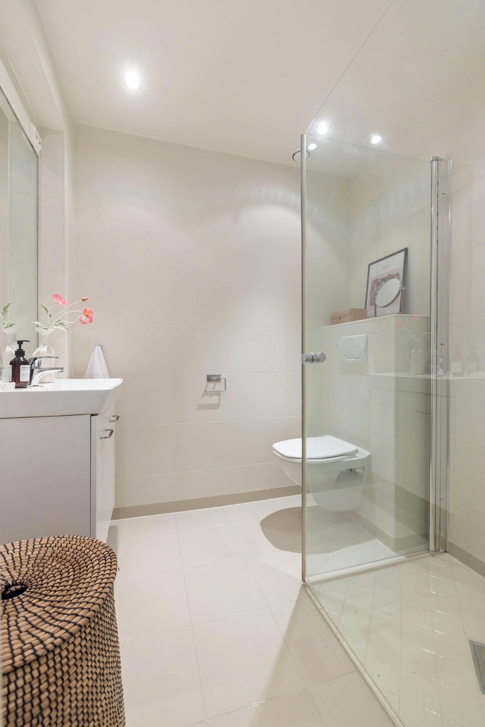 Servantskap med glatte hvite fronter, hvit keramisk servant og ettgreps blandebatteri i rustfritt stål fra Oras. Galleribilde