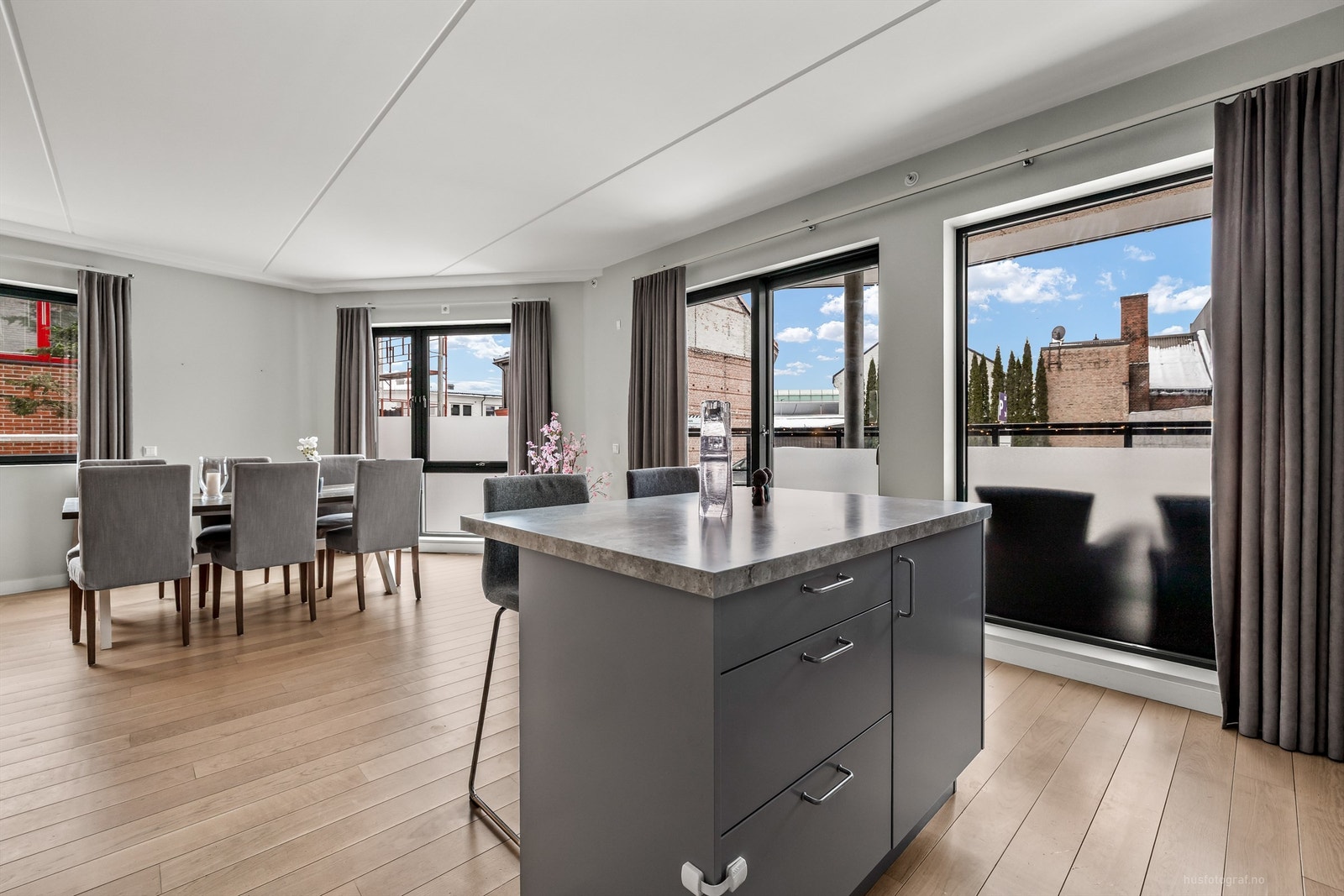 Åpen kjøkken- og stueløsning med sofaområde samt spiseplass Galleribilde