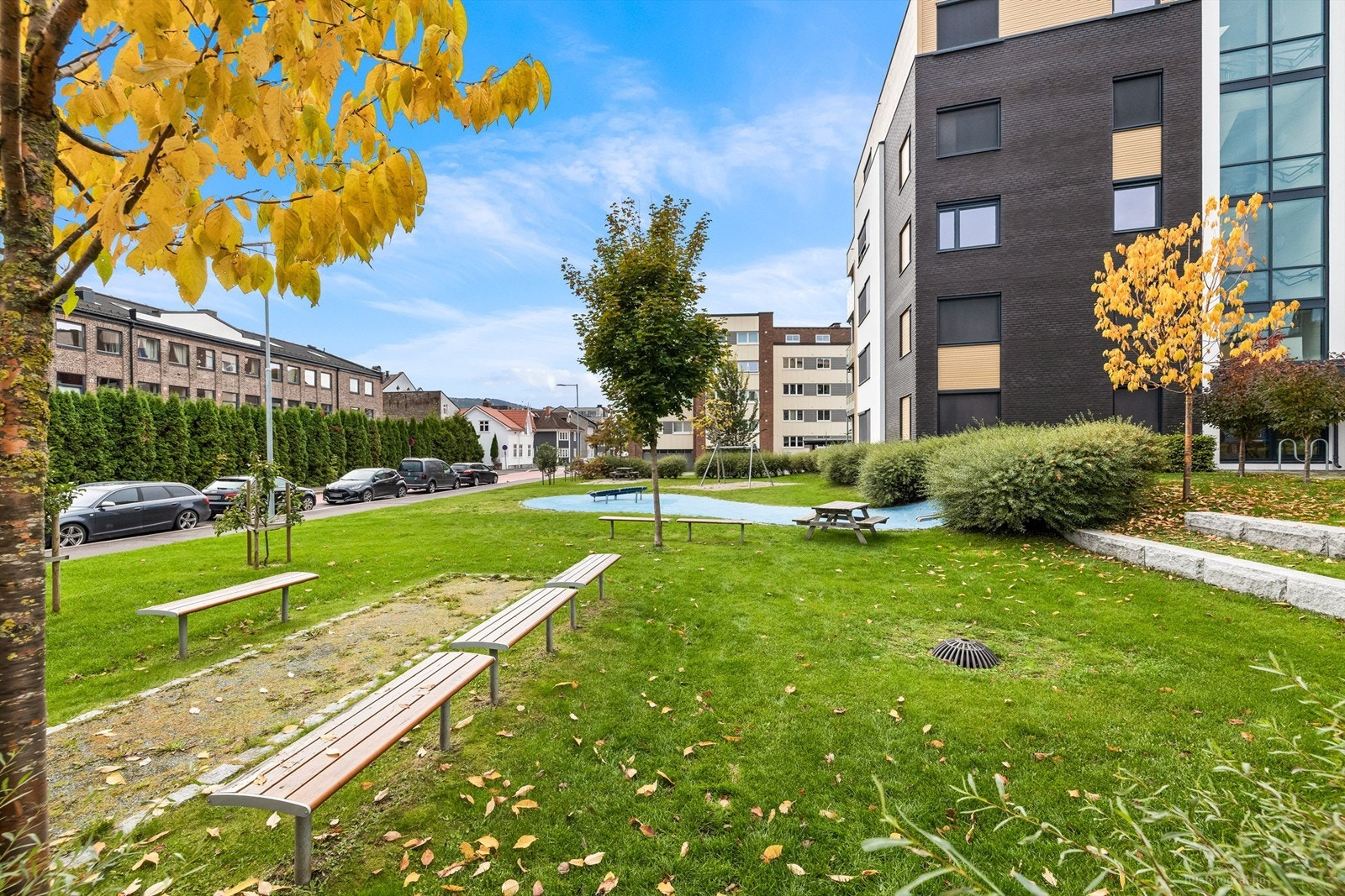 Felles atrium og parkområde med sitteplasser samt lekeapparater Galleribilde