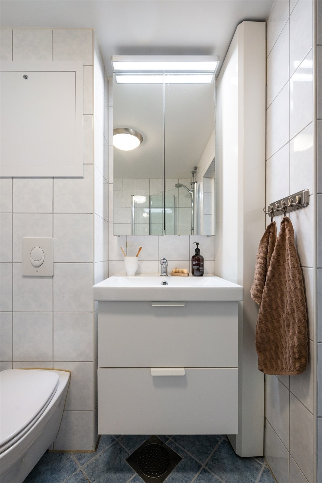 Badet har også opplegg for vaskemaskin og mekanisk avtrekk. Flislagt gulv og vegger, samt plater i himling, gir et praktisk og tidløst uttrykk. Galleribilde