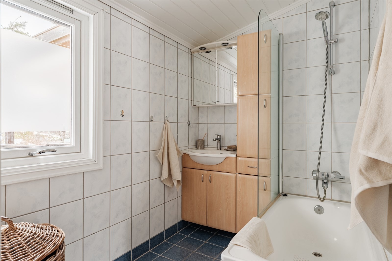 Badekar med glassdør og dusjarmatur tilkoblet veggmontert hånddusj. God plass til oppbevaring i skap. Galleribilde