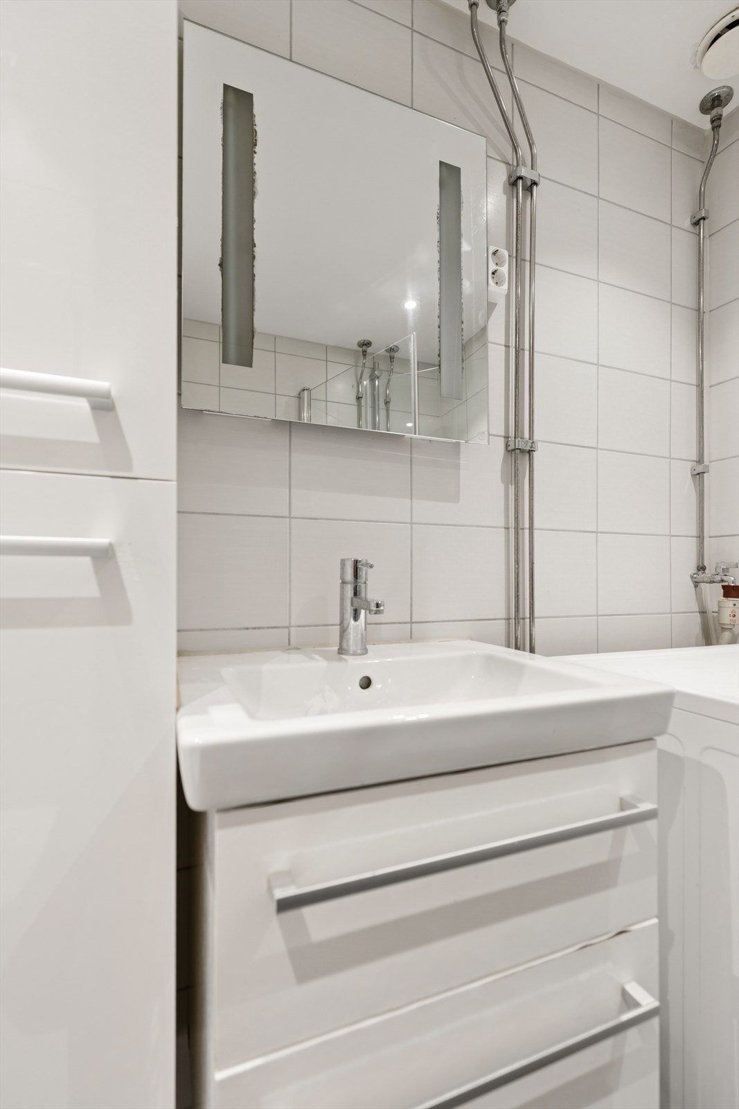 Badet har servantinnredning, høyskap, vegghengt toalett og opplegg for vaskemaskin. Galleribilde