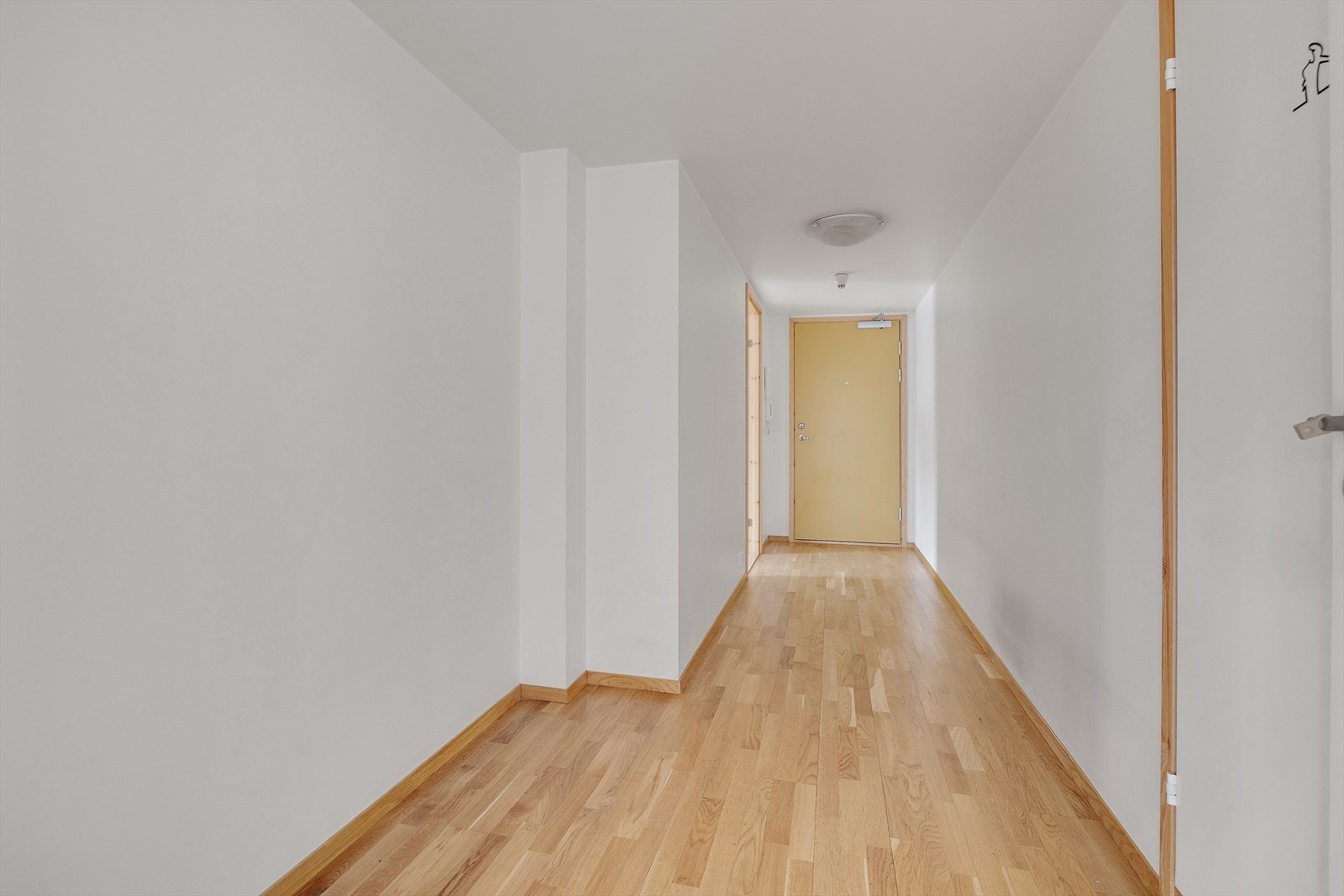 Her trer du inn i en langstrakt og romslig entré med plass til oppbevaring av yttertøy i en praktisk skyvedørsgarderobe med speilfronter. Galleribilde