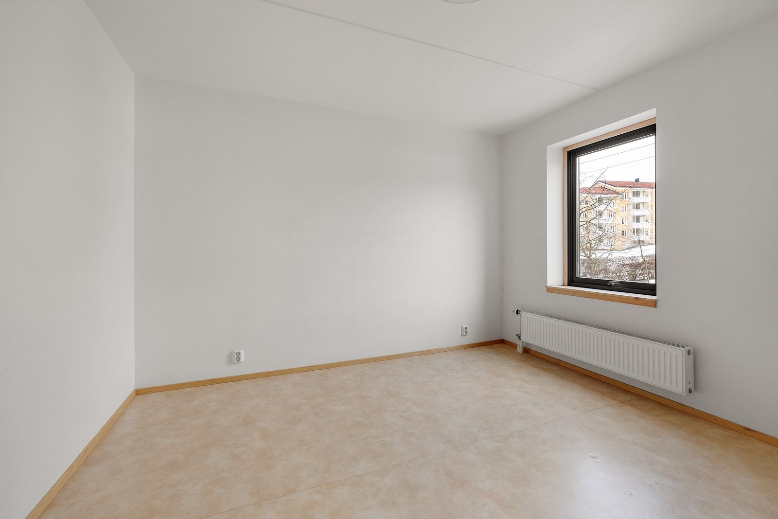 Lyst rom med slettmalte vegger og parkettgulv, ideelt for bruk som soverom eller kontor. Galleribilde