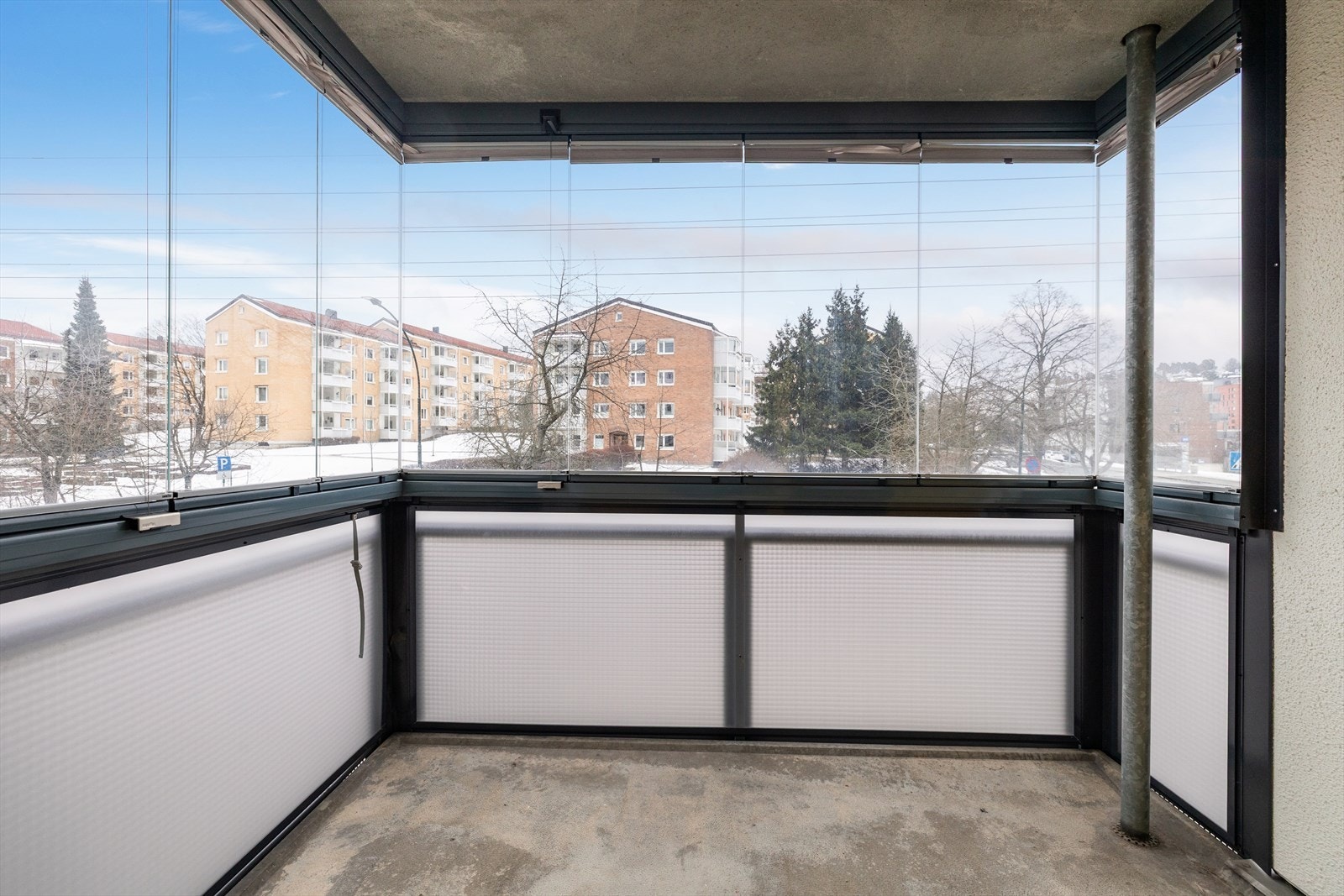 Utsyn mot grøntområde og boligblokker gir en behagelig utsikt fra balkongen. Galleribilde