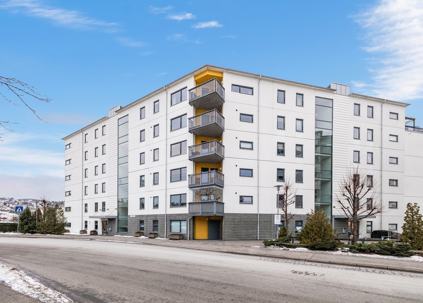 Bygningen har en moderne fasade med flere balkonger og store vindusflater. Galleribilde