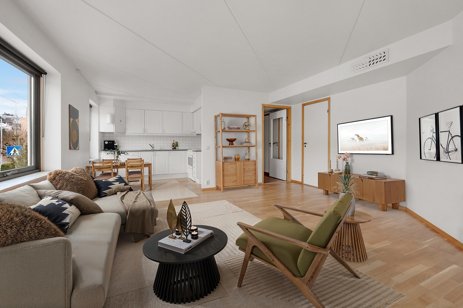 Lys og luftig stue i åpen løsning med kjøkkenet. Bildet er digitalt stylet. Galleribilde